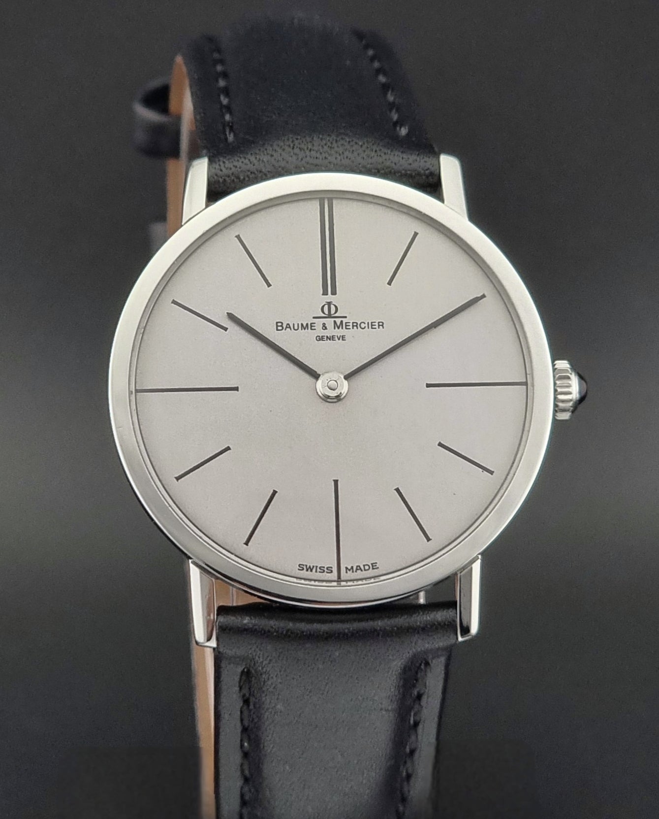 Baume & Mercier watch with black leather strap on a dark background