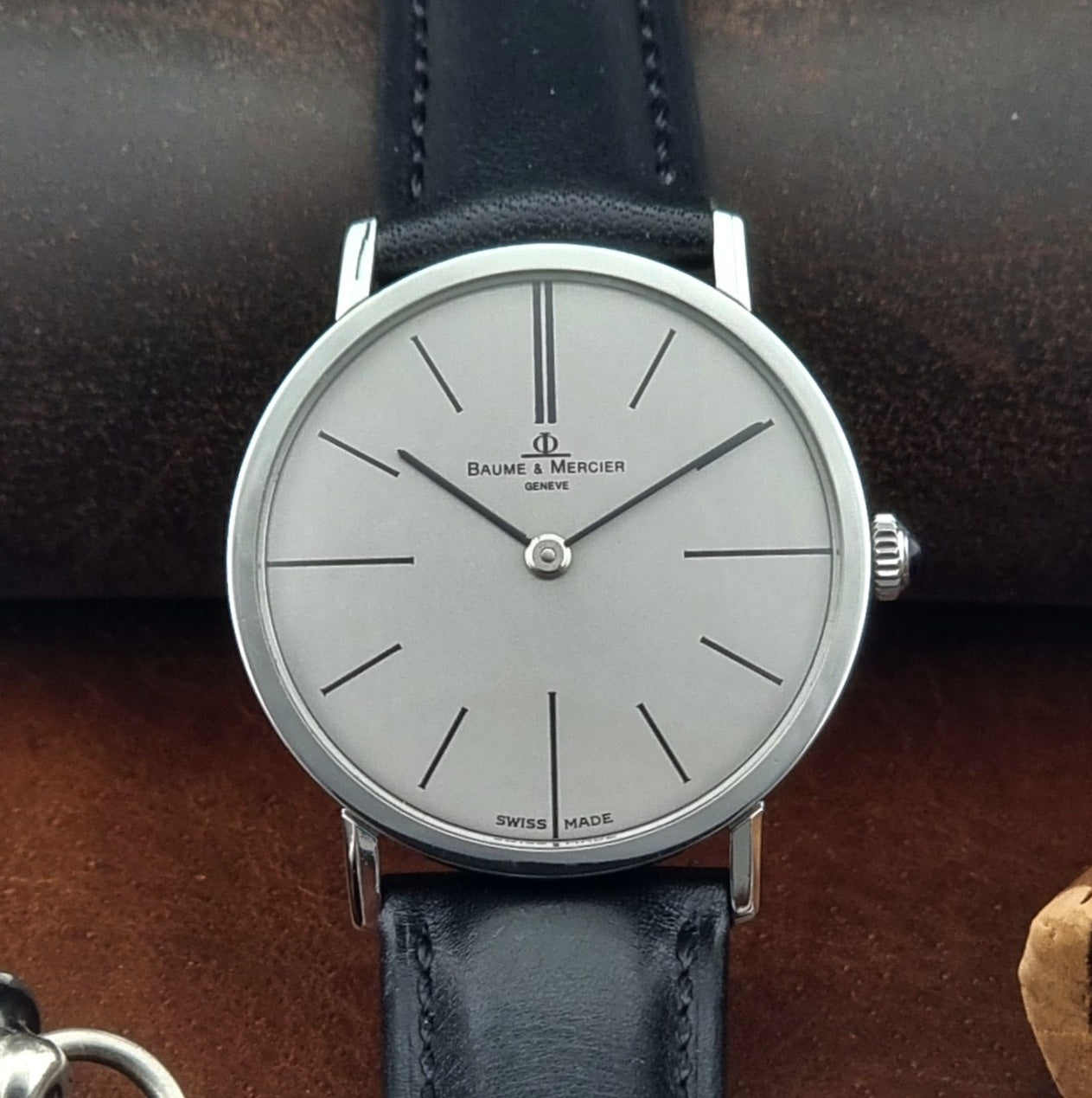 Baume & Mercier watch with black leather strap on a dark background