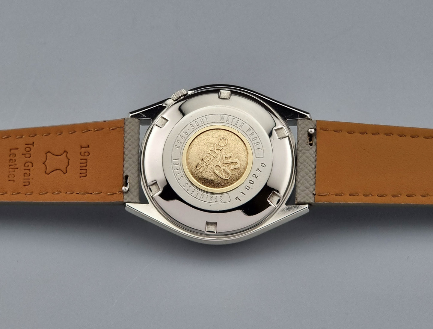 Watch back cover with Grand seiko logo on a gray background