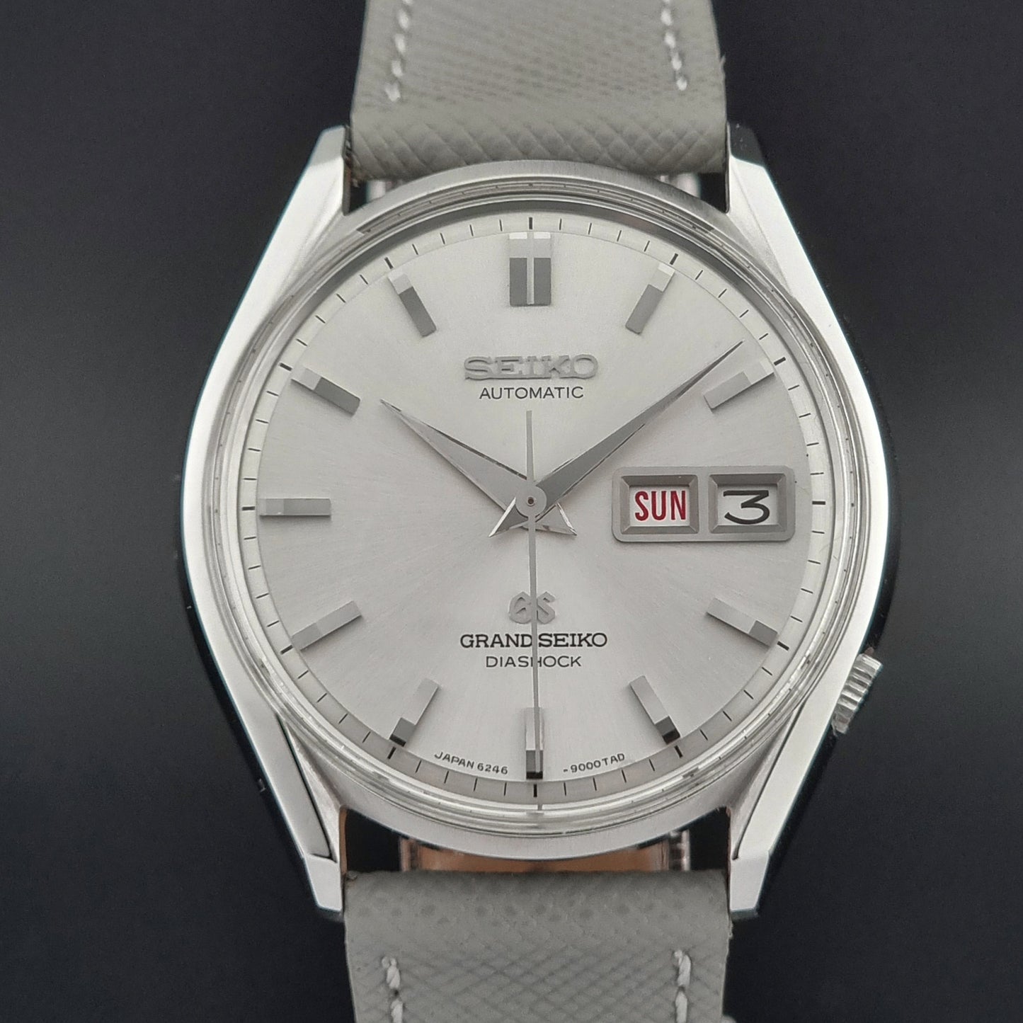 Grand Seiko watch with gray strap on a dark background
