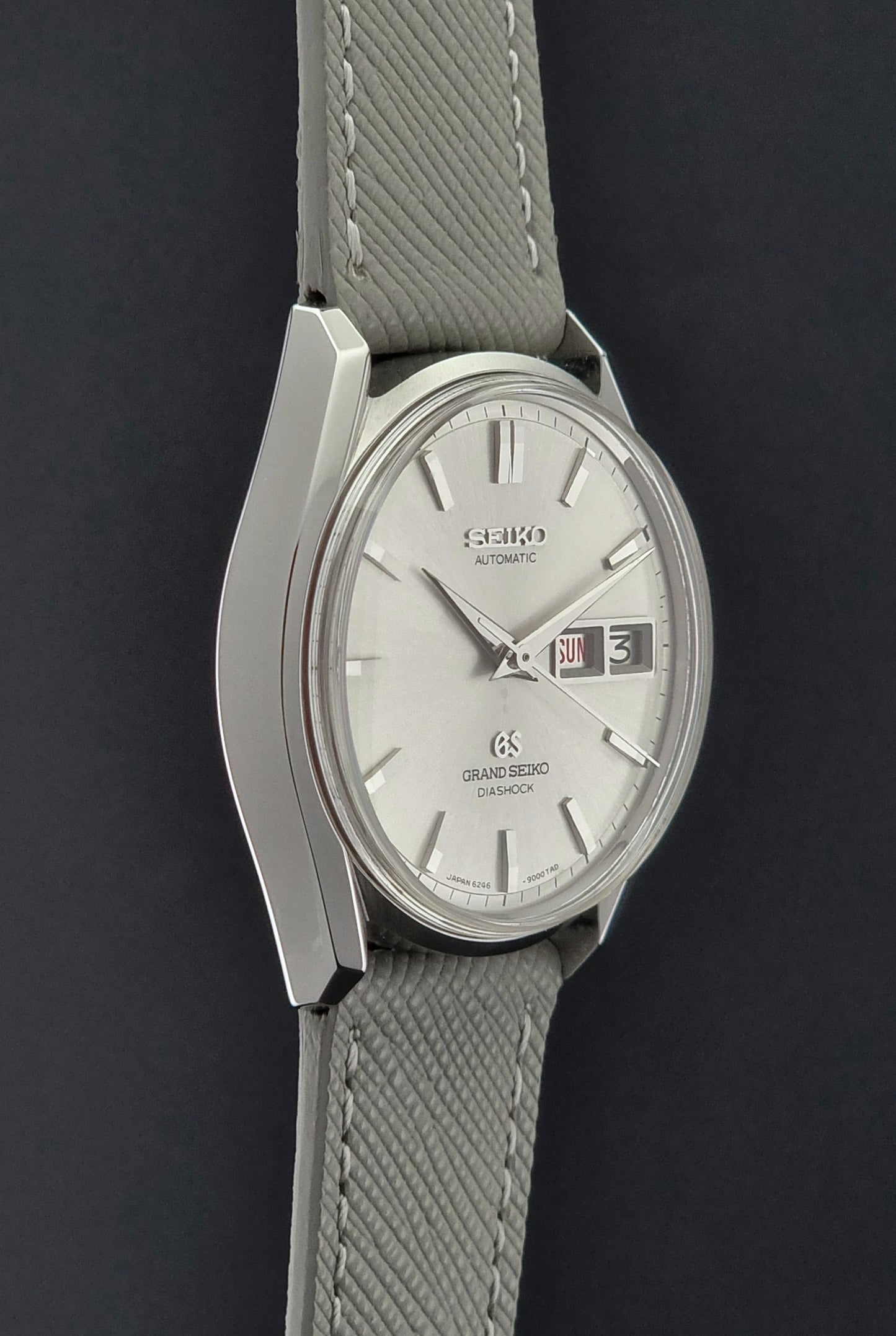 Vintage Grand Seiko watch with gray strap on a dark background
