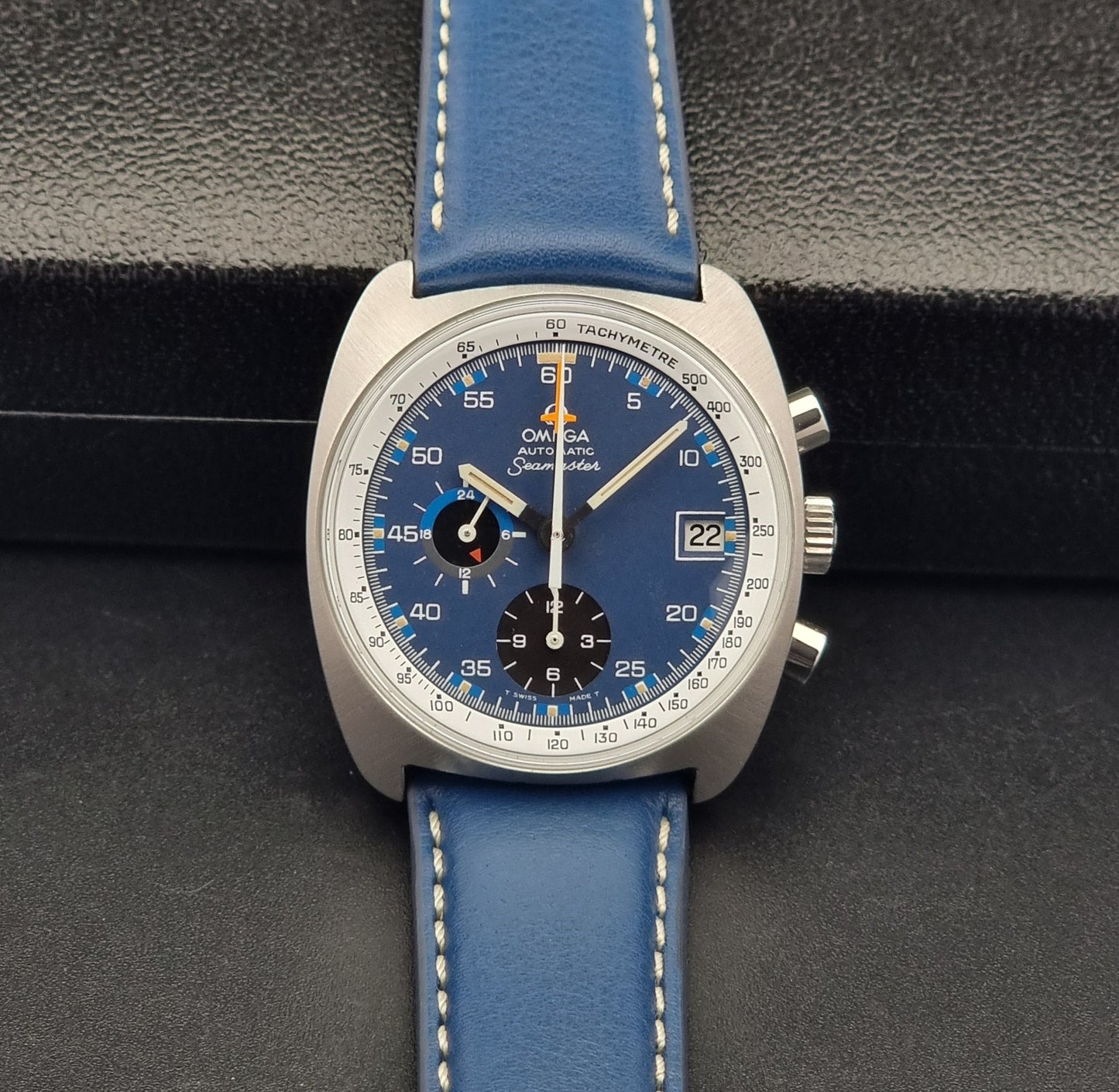Vintage Omega Seamaster watch with blue strap on a dark background