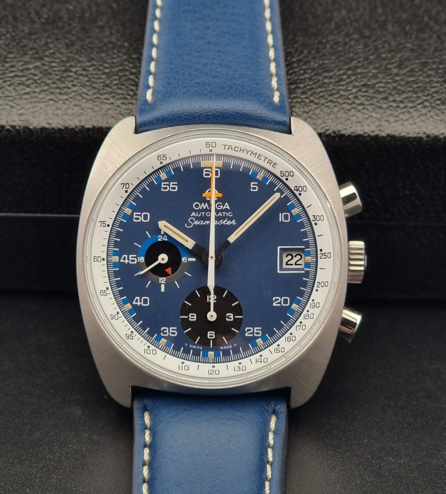 Vintage Omega Seamaster watch with blue strap on a dark background