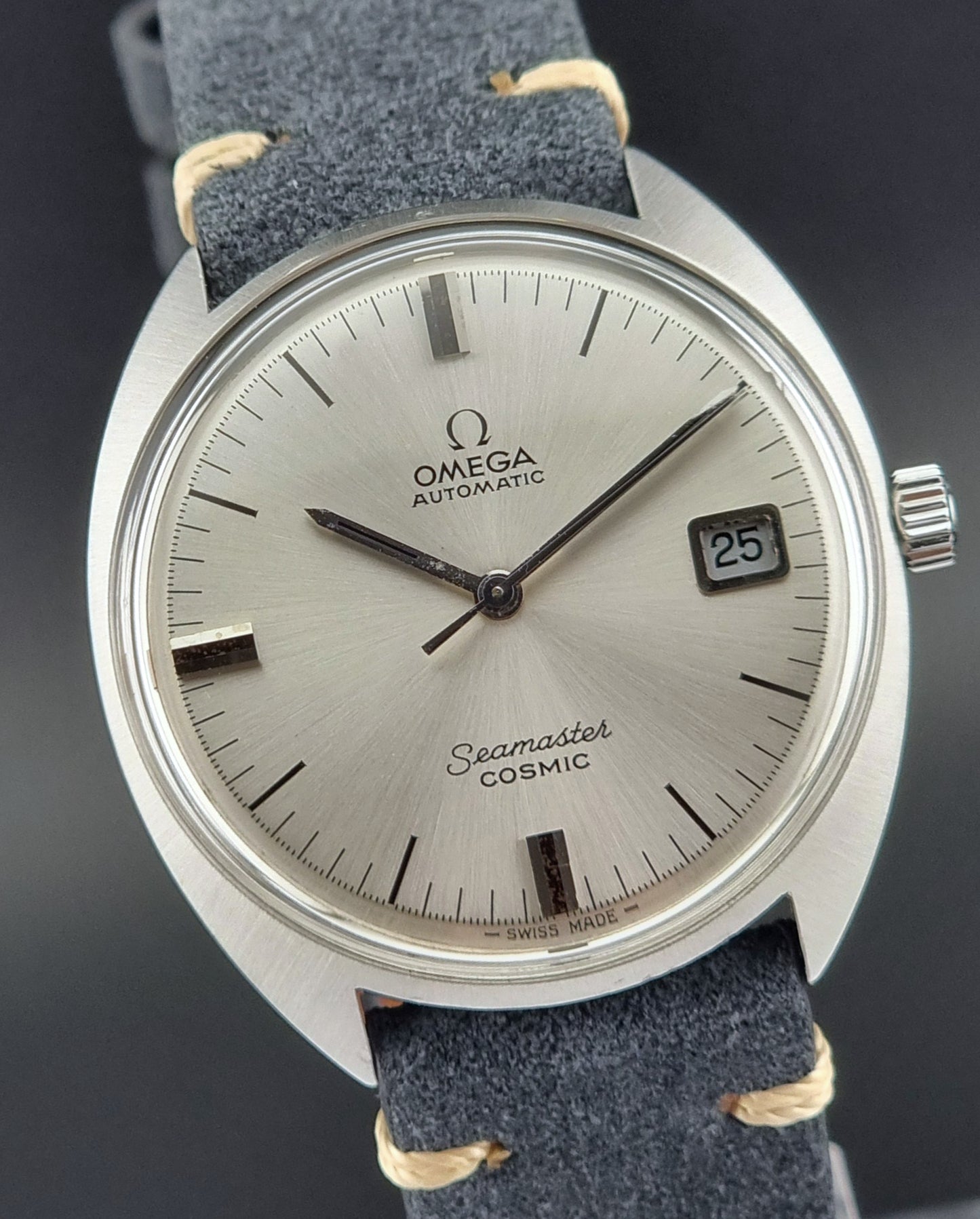 Omega Seamaster Cosmic watch with silver dial and blue strap on a dark background