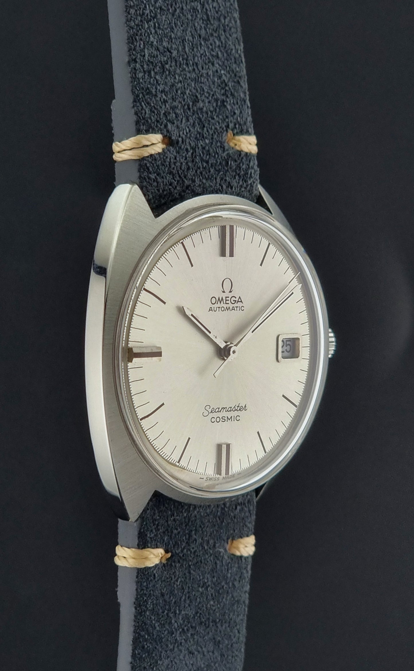 Vintage Omega Seamaster watch with a blue strap on a dark background