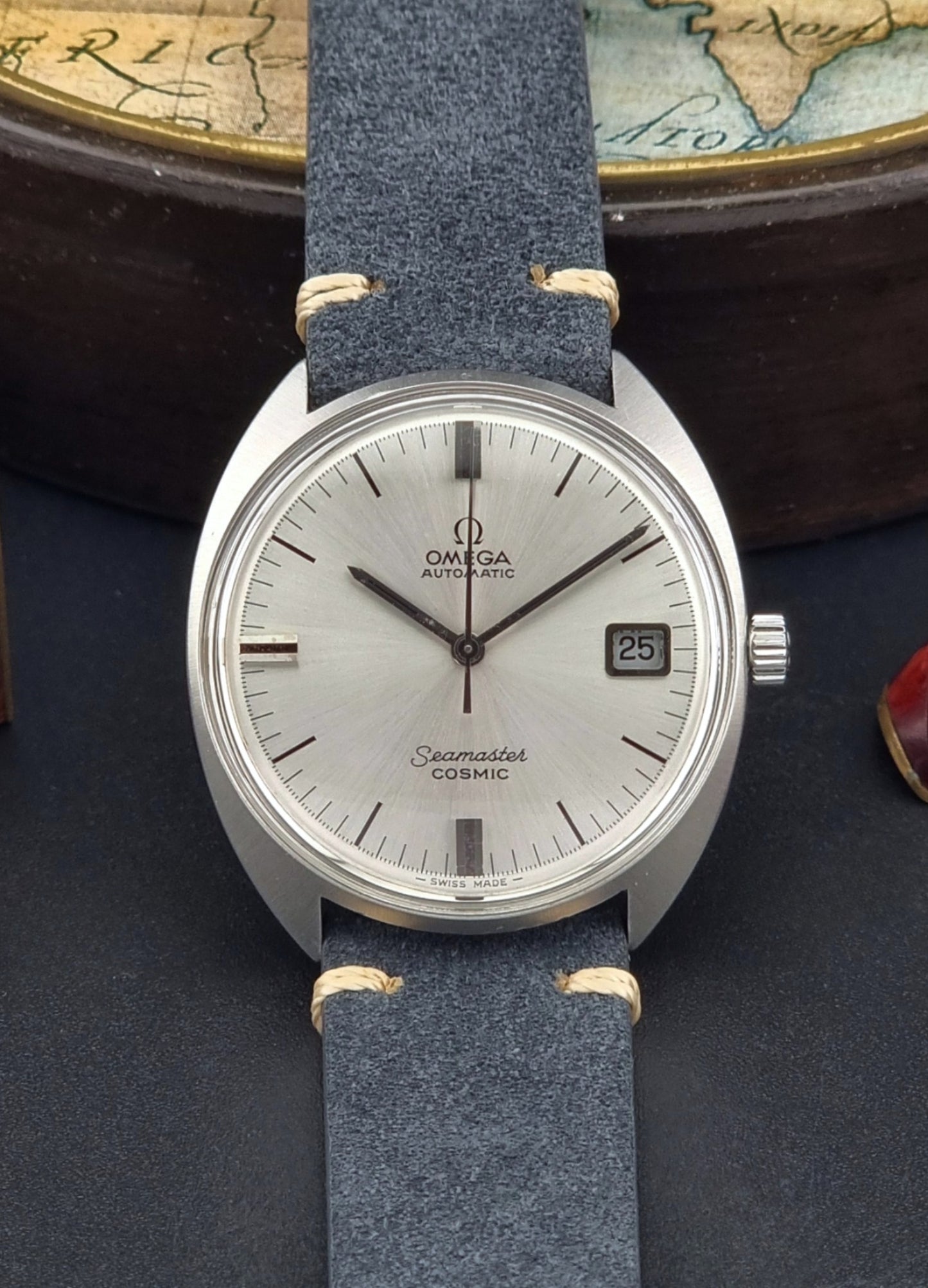 Vintage Omega Seamaster watch with blue strap on a dark surface