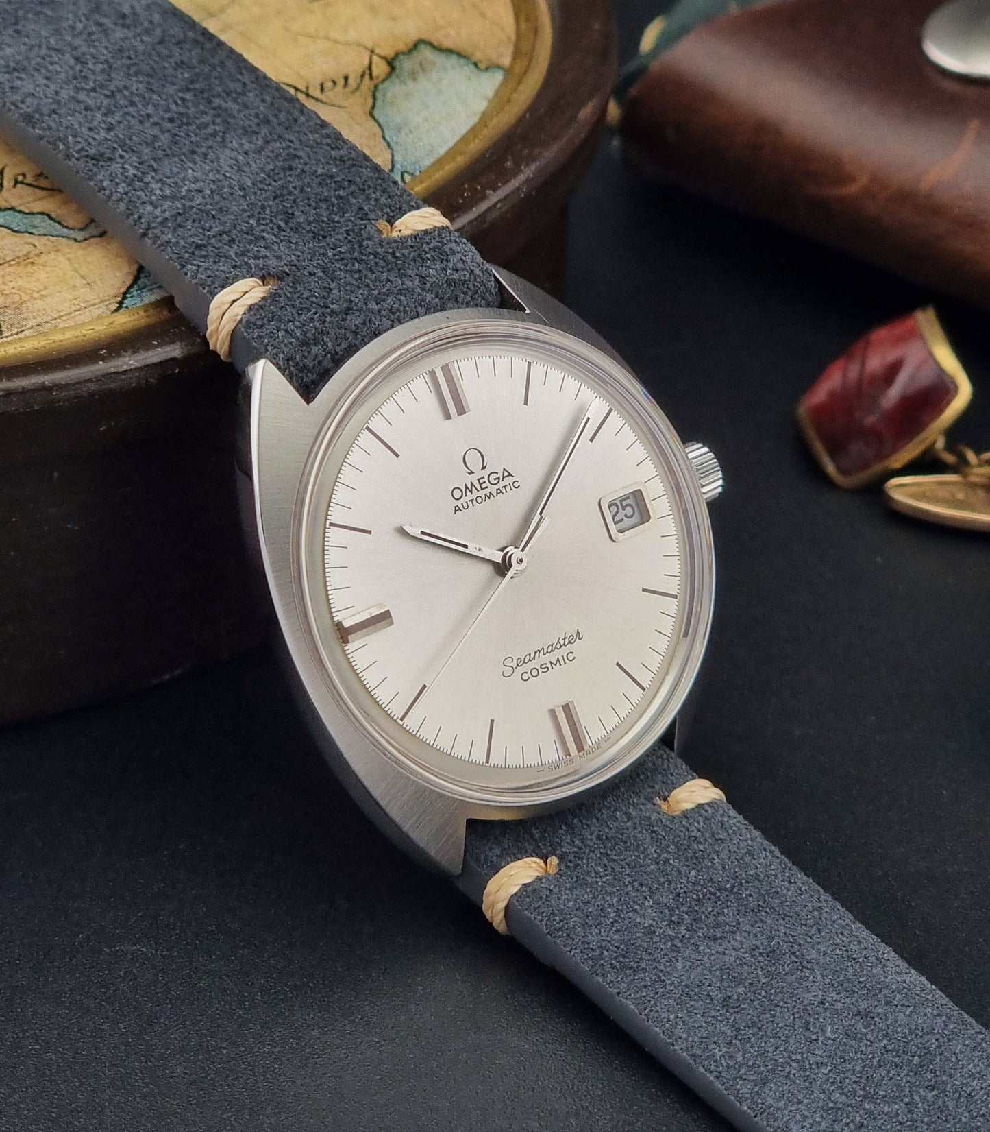 Vintage Omega Seamaster watch with blue strap on a dark surface