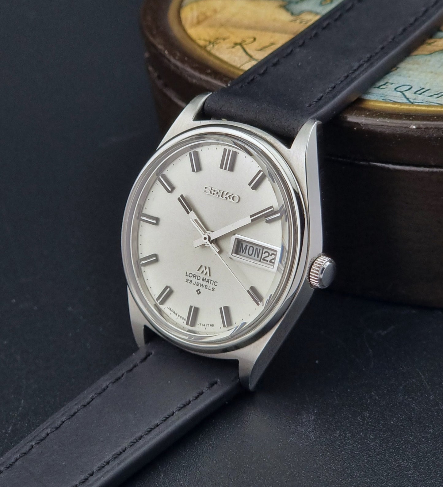 Vintage Seiko Lord Matic watch with black strap on a dark surface