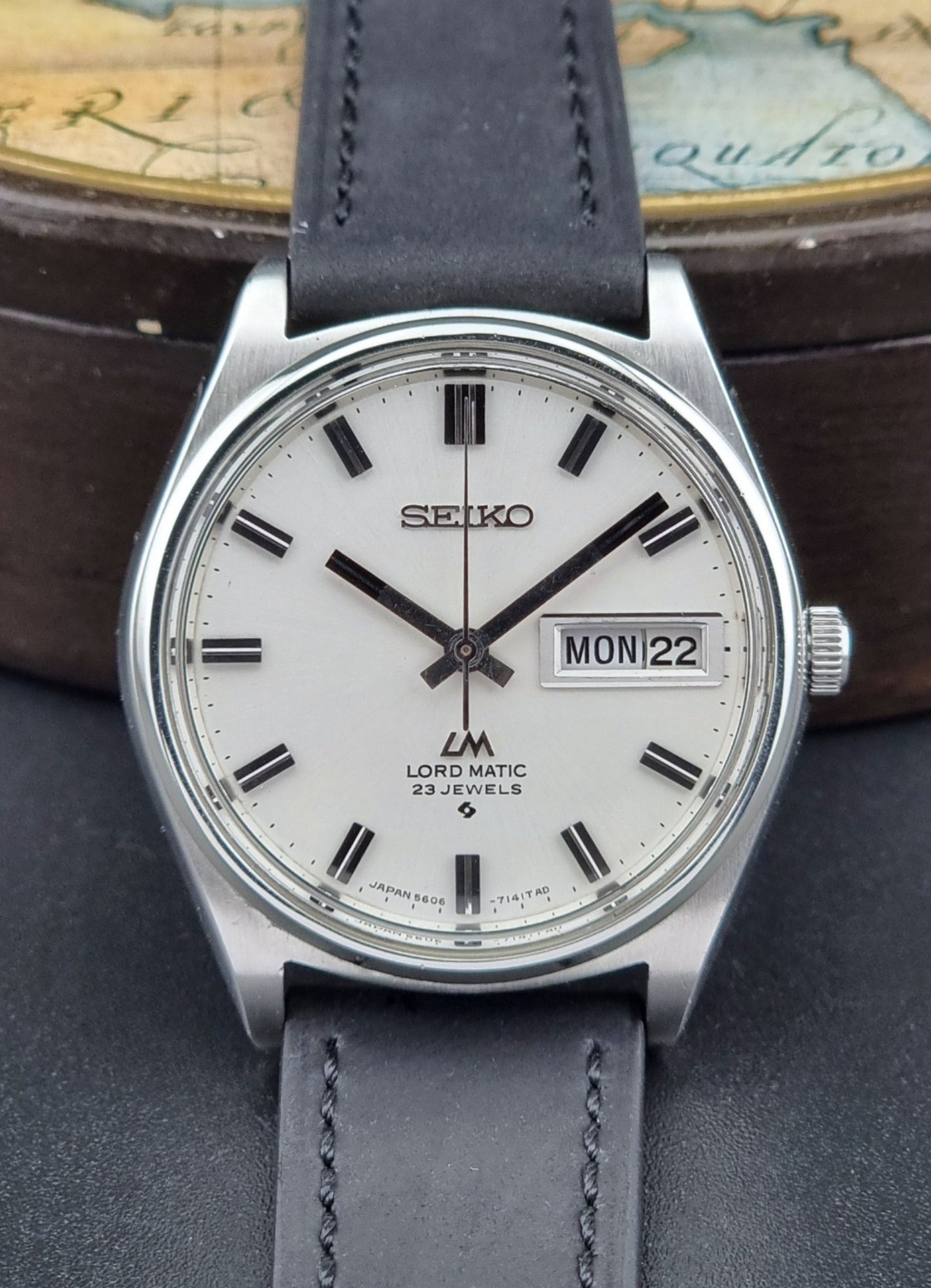 Vintage Seiko Lord Matic watch with a gray strap on a dark surface