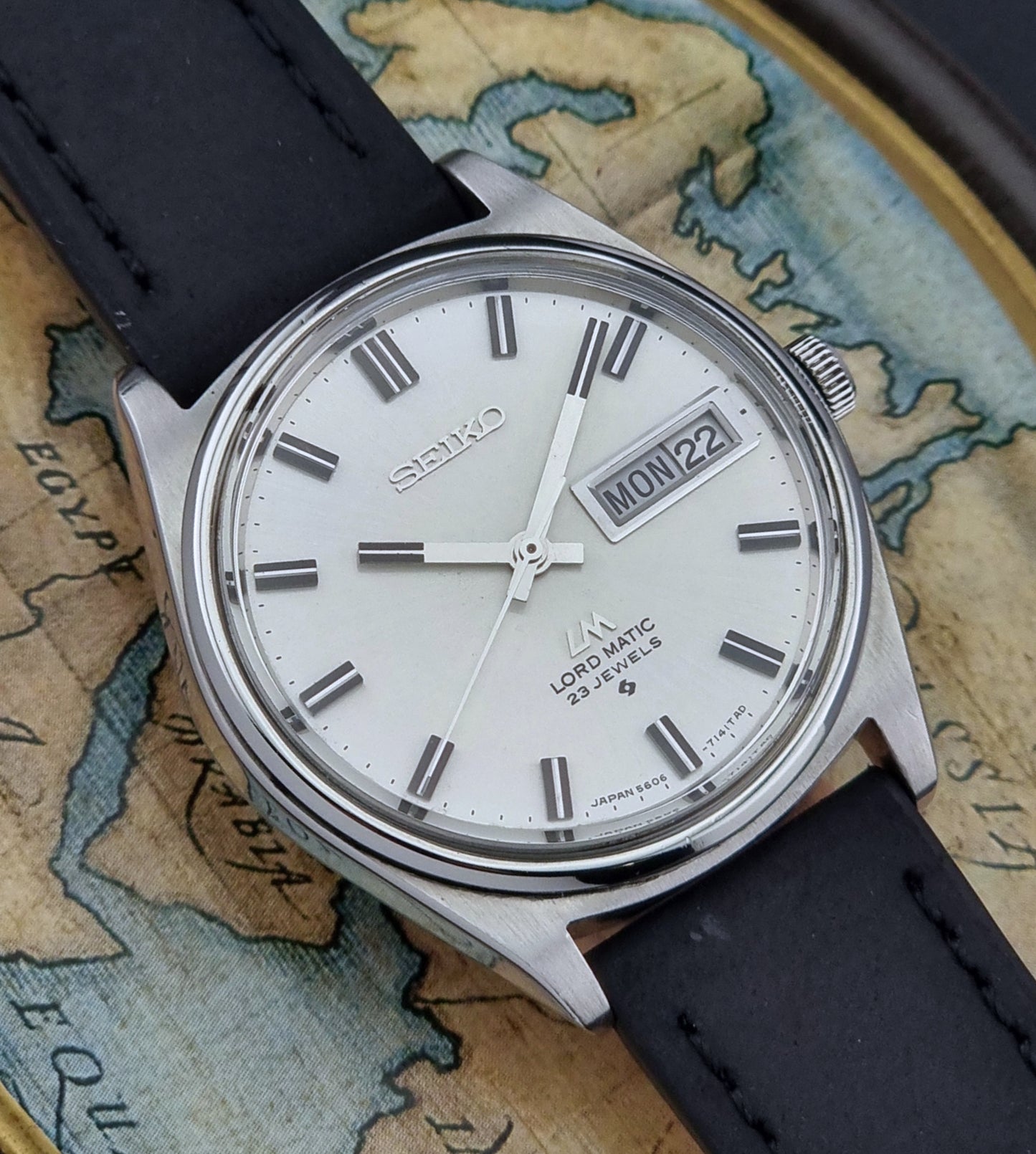 Vintage Seiko Lord Matic watch with black strap on an old map background