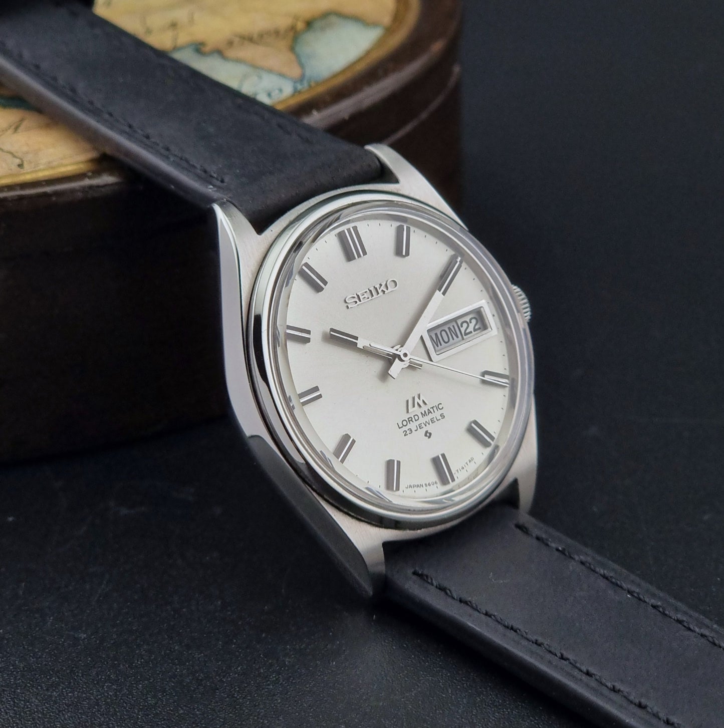 Vintage Seiko Lord Matic watch with black leather strap on a dark surface