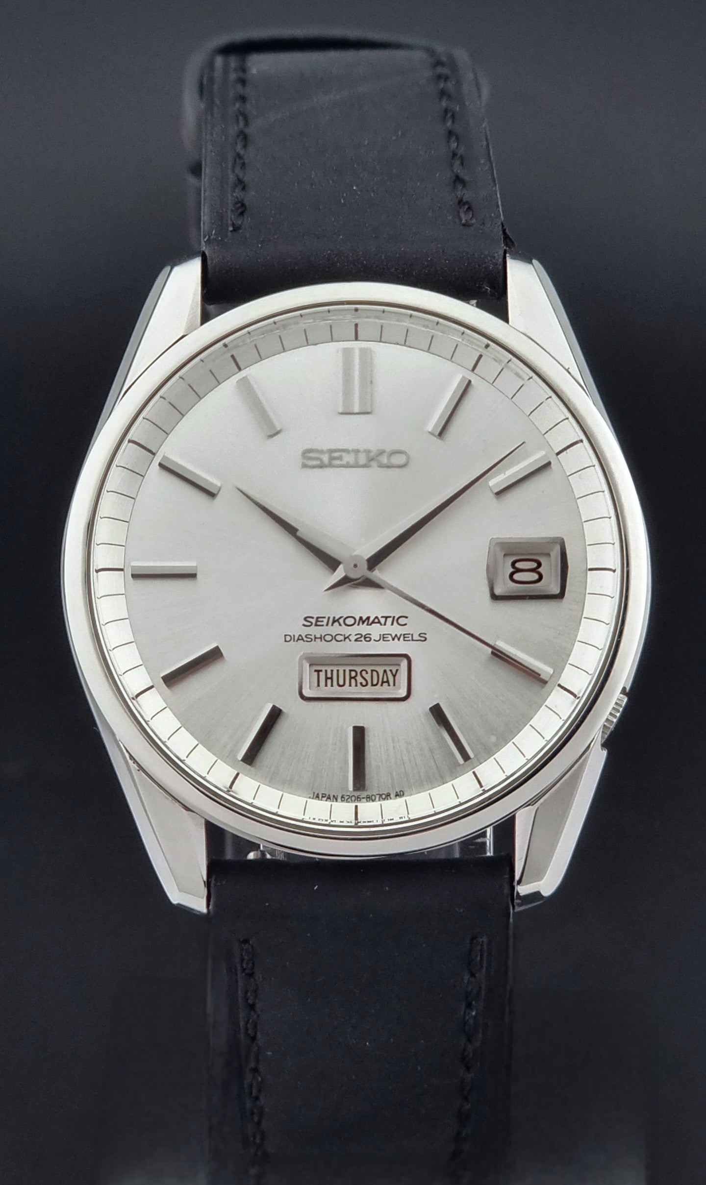 Seiko Seikomatic 6206-8040 Wristwatch with black leather strap on a dark background