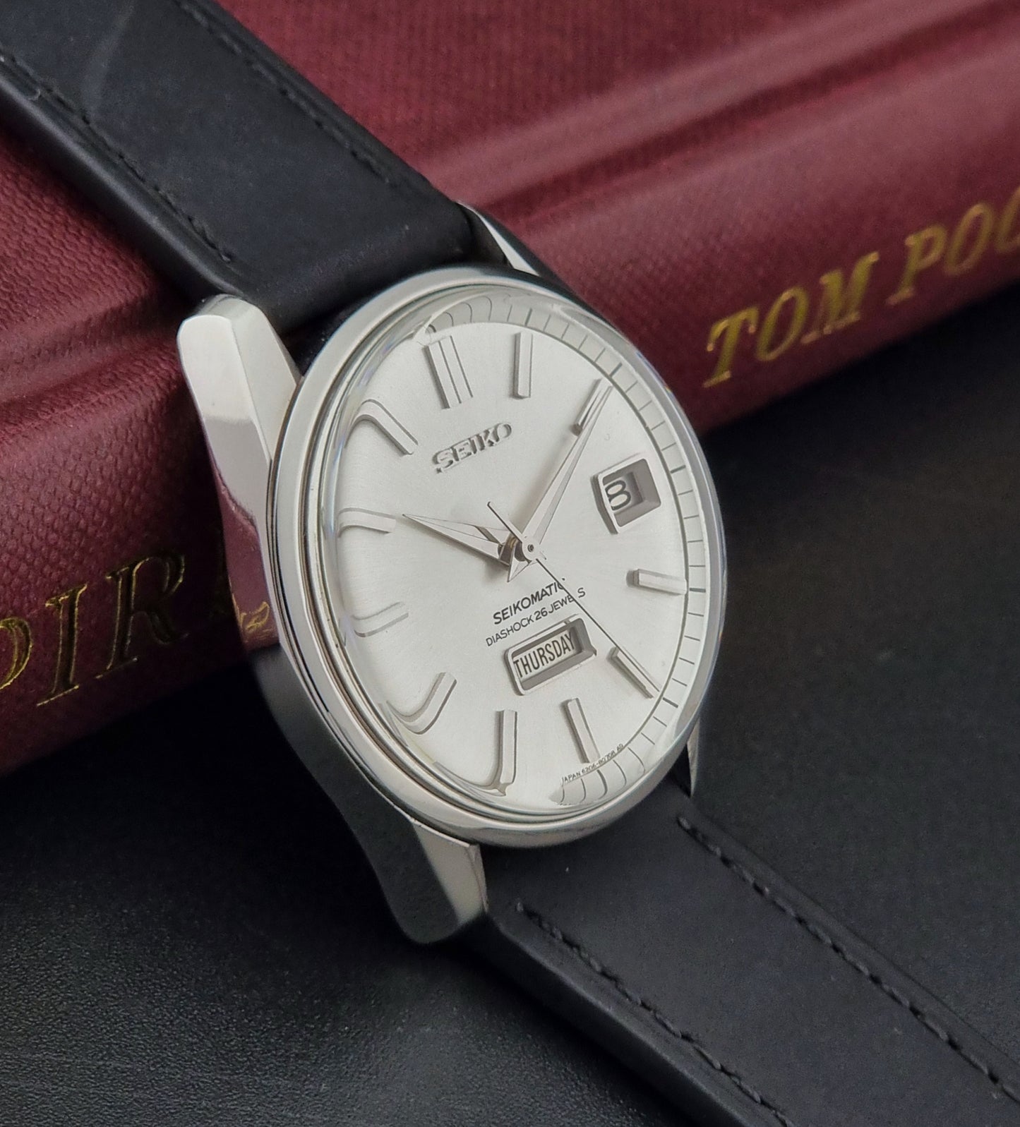 Seiko Seikomatic 6206-8040 Wristwatch with black leather strap on a dark surface
