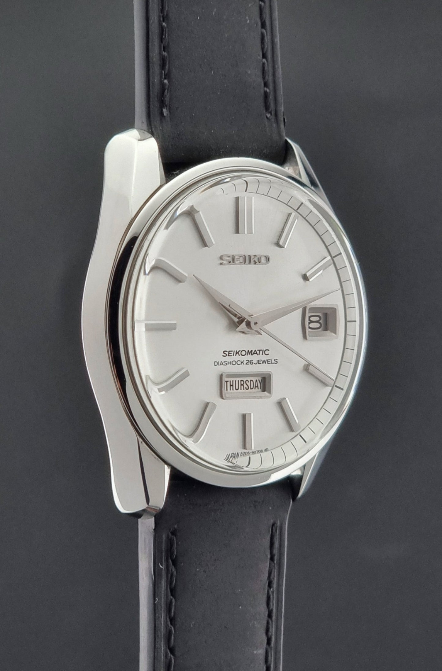 Seiko Seikomatic 6206-8040 Wristwatch with black leather strap on a dark background
