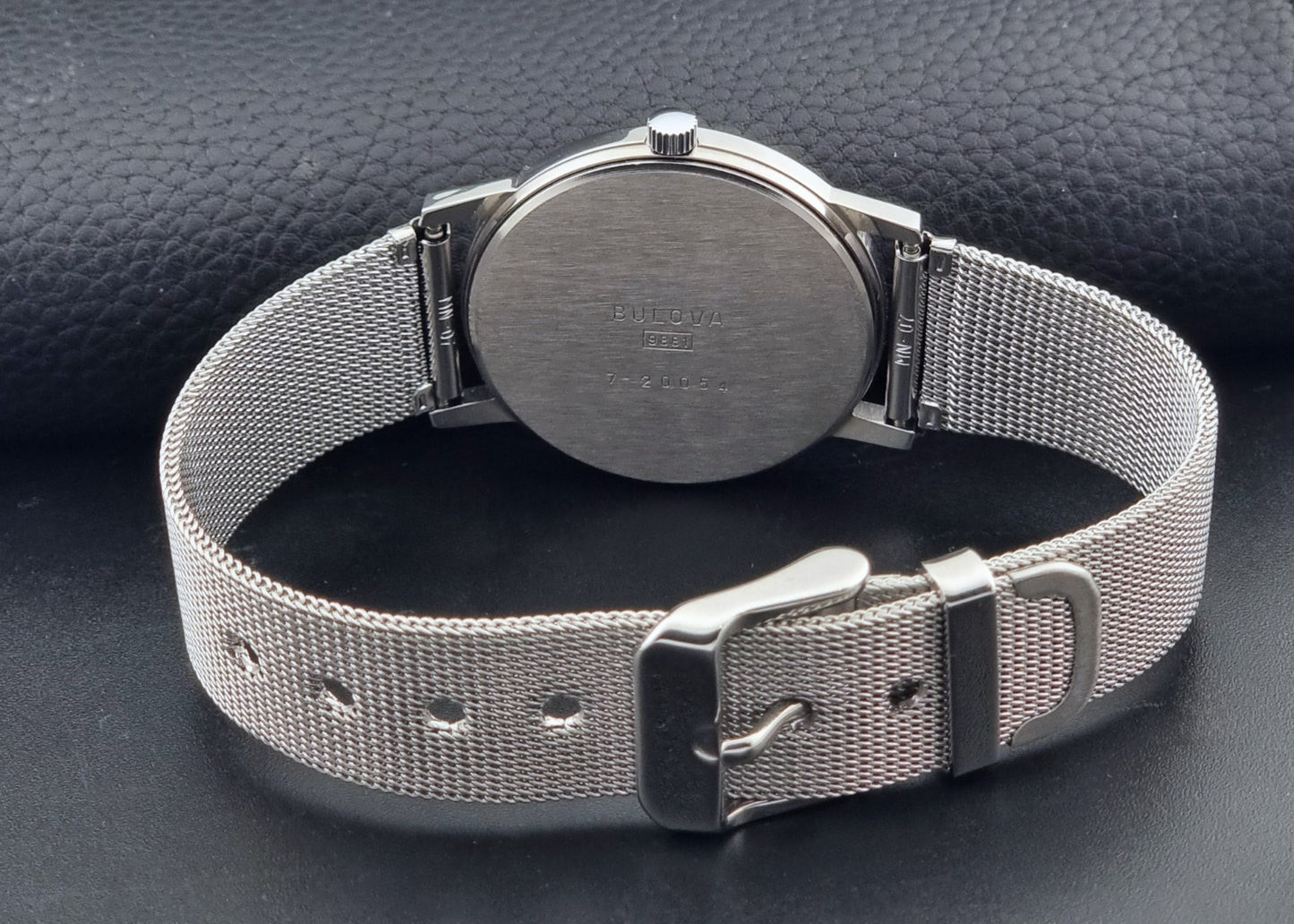 Vintage Bulova 9881 wristwatch Longchamps co-signed dial with a mesh band on a dark gray background bracelet view