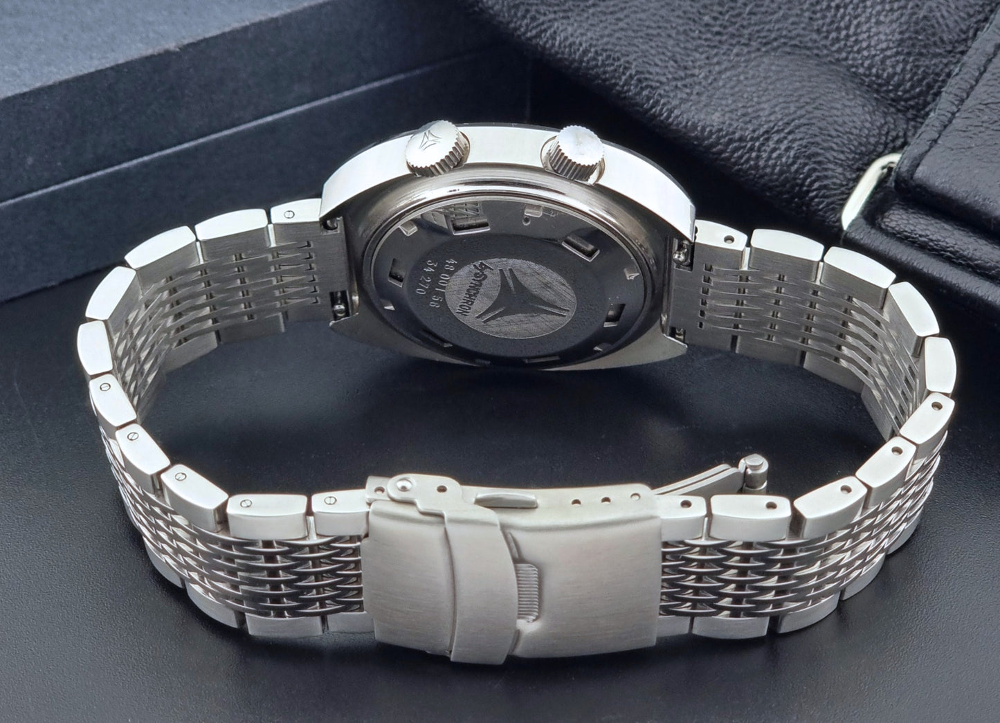 Vintage Cyma Alarm watch by Synchron a Conquistador 34270 with a detailed face on a dark surface bracelet view