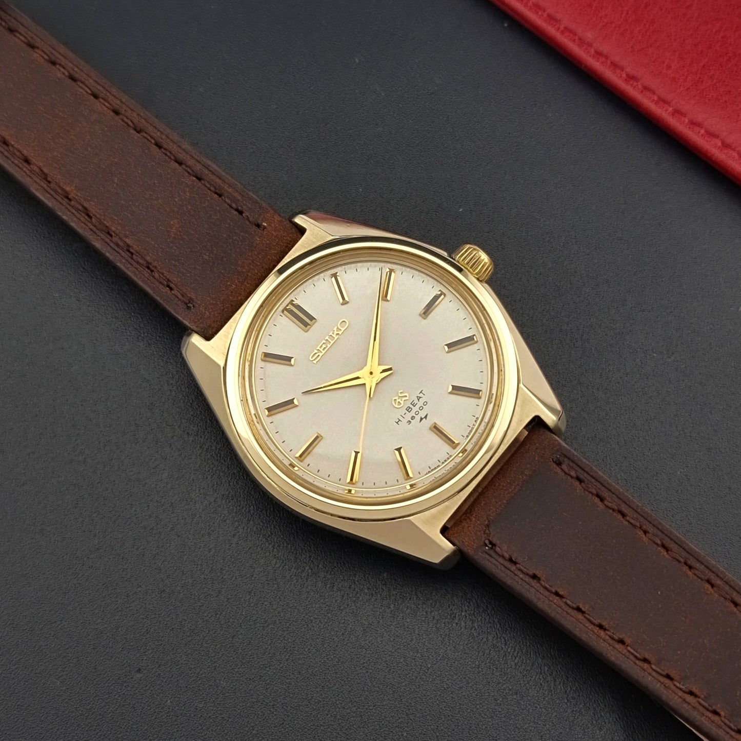 Vintage Grand Seiko 4520-8000 gold watch with brown leather strap on a dark background