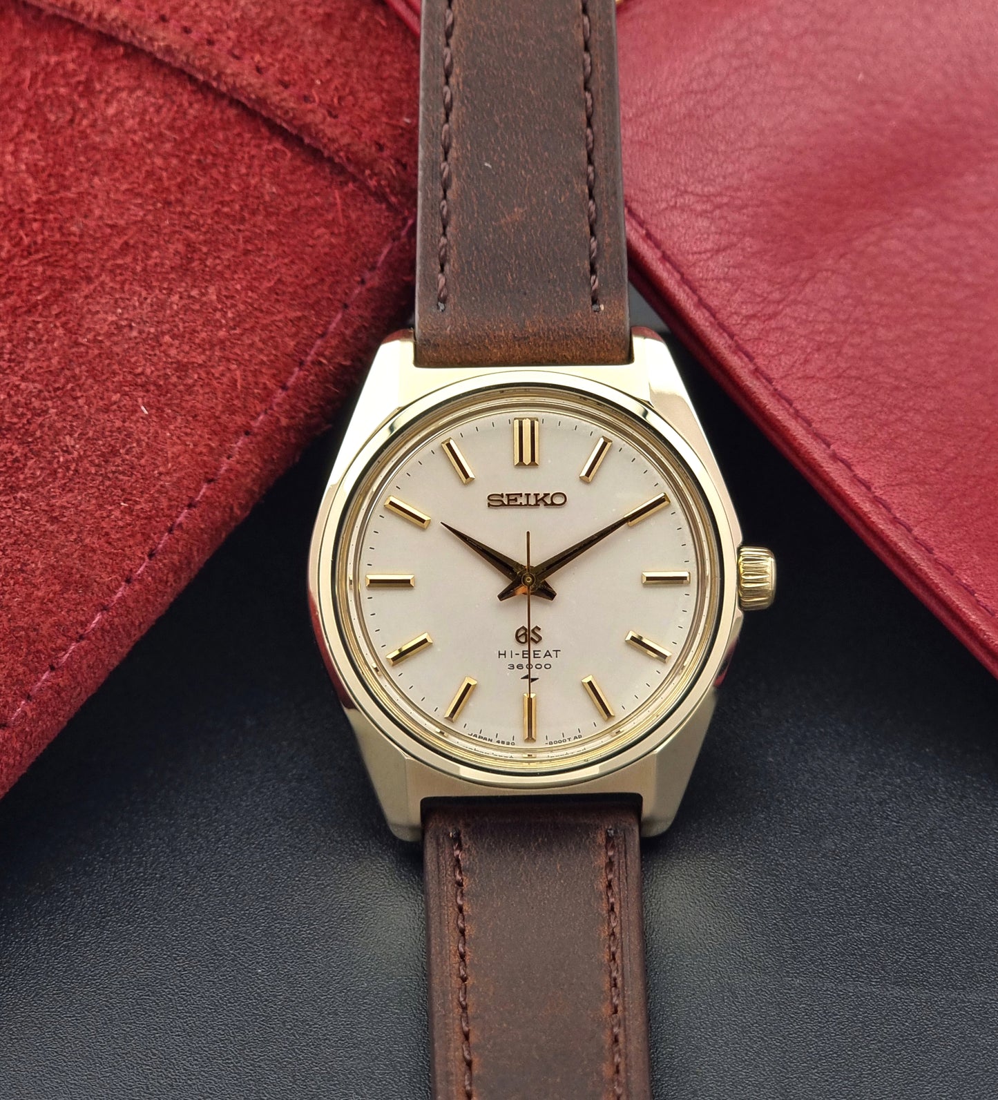 Vintage Grand Seiko 4520-8000 gold watch with brown leather strap on a dark background front view