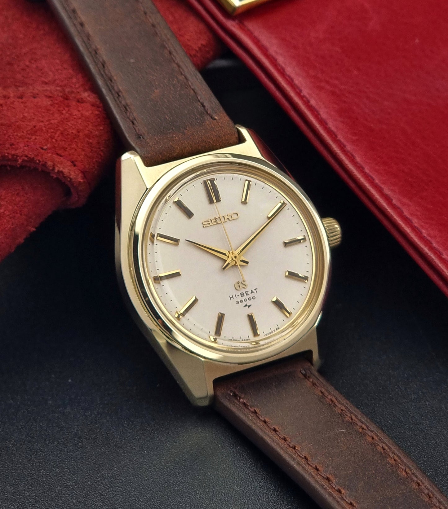 Vintage Grand Seiko 4520-8000 gold watch with brown leather strap on a dark background side view