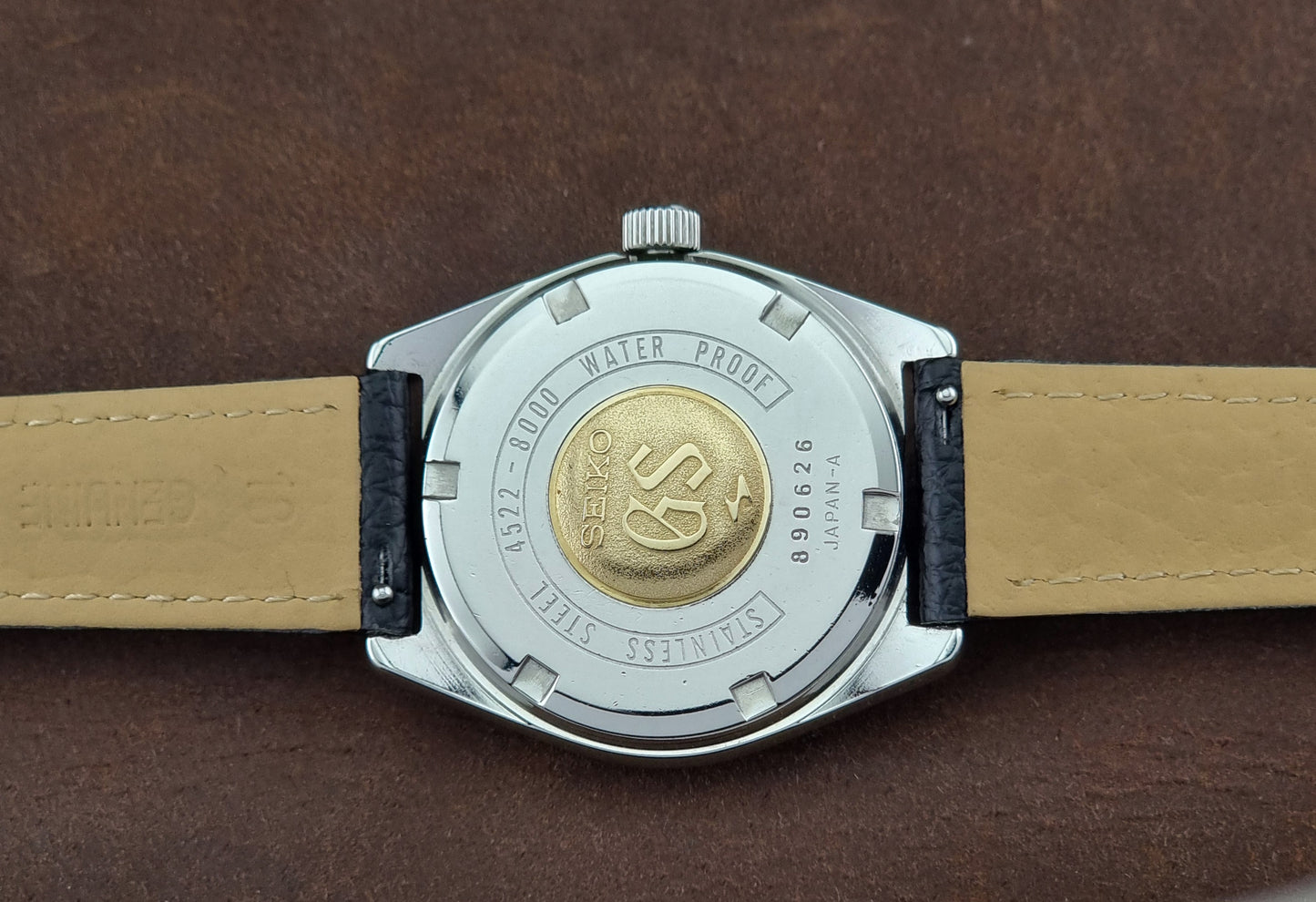 Close-up of a Vintage Grand Seiko watch case back on a brown background