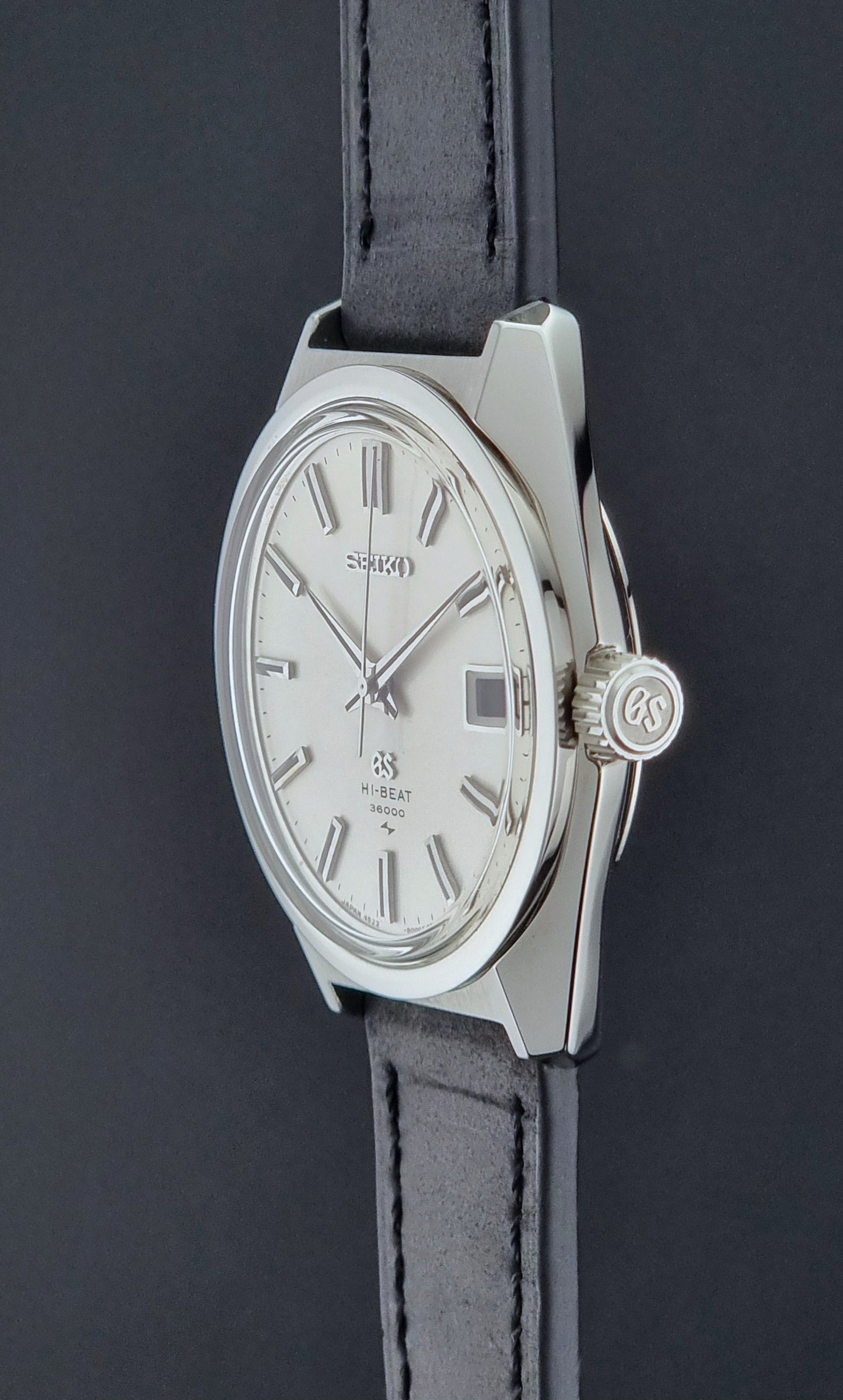 Vintage Grand Seiko 4522-8000 Wristwatch with silver case and black leather strap on a dark background