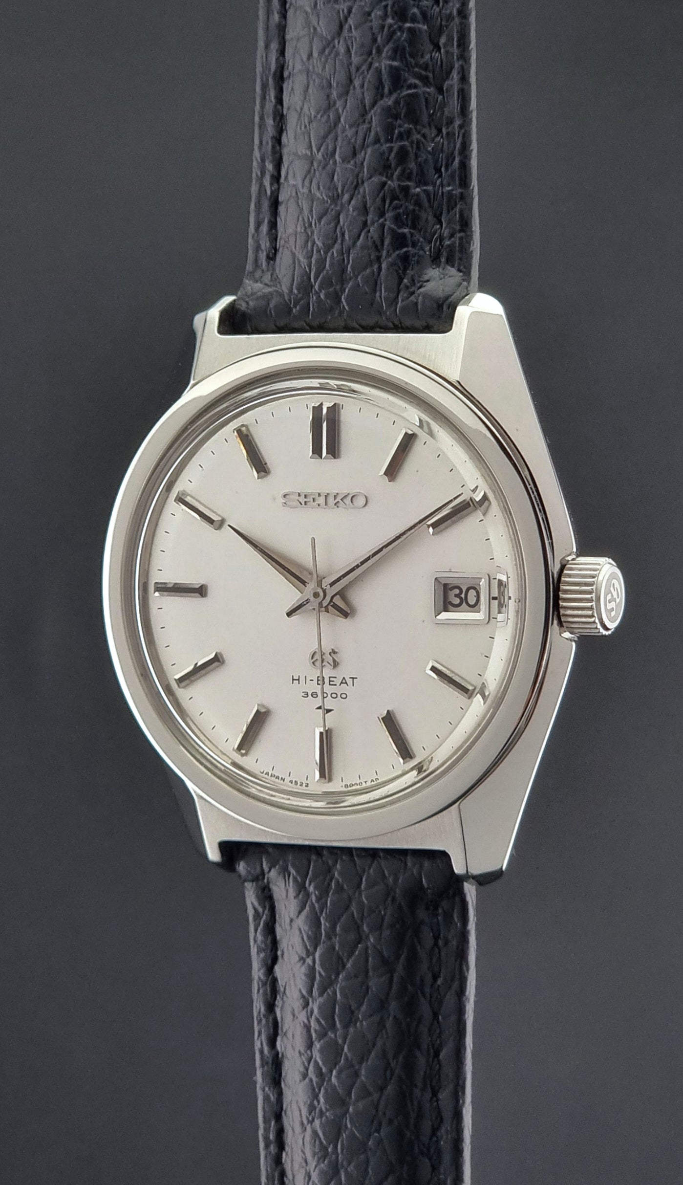 Vintage Grand Seiko watch with black leather strap on a dark background