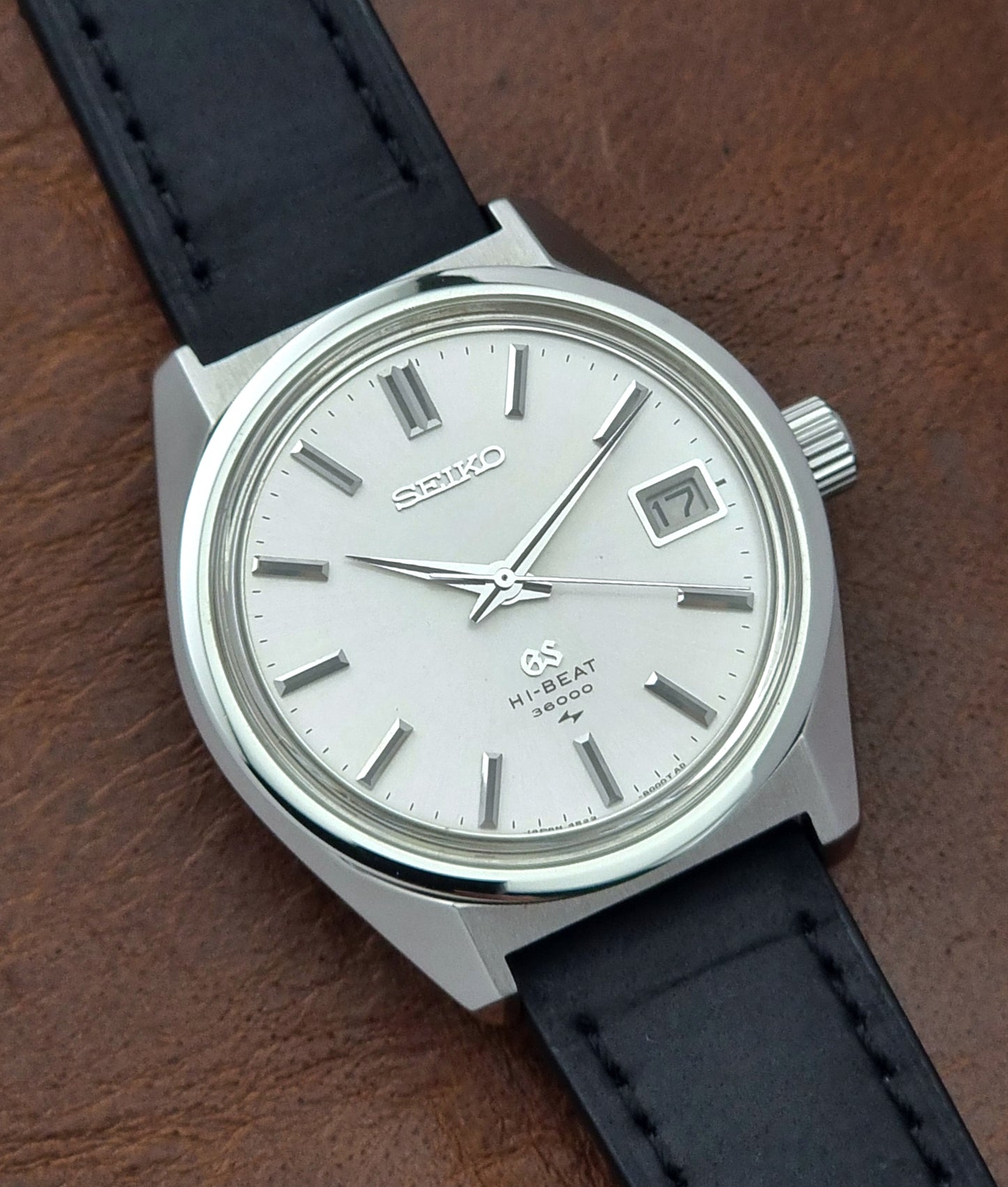 Vintage Grand Seiko 4522-8000 watch with black leather strap on a wooden surface