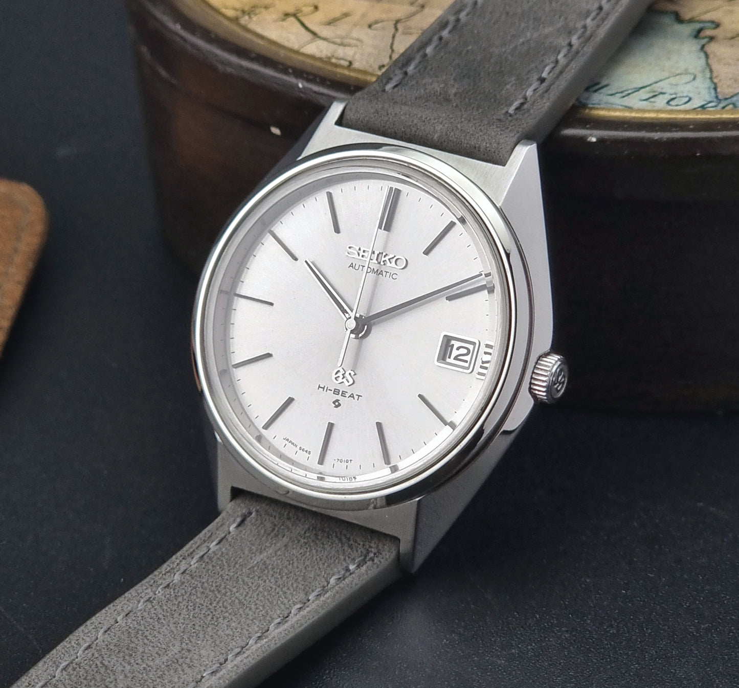 Vintage Grand Seiko watch with gray leather strap on a dark surface