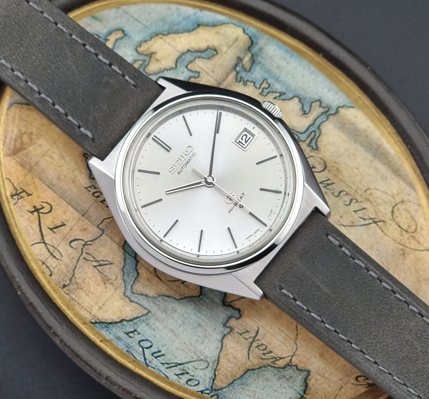 Vintage Grand Seiko Watch with gray strap on an old map background