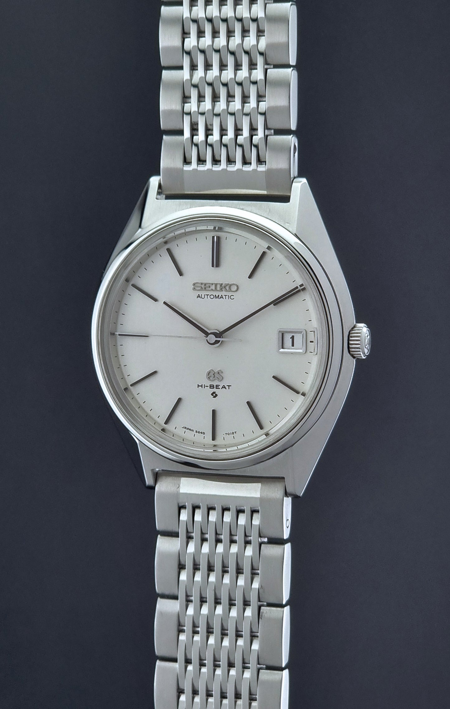 Vintage Grand Seiko Wristwatch 5646-7010 with a white face on a dark background crown side profile
