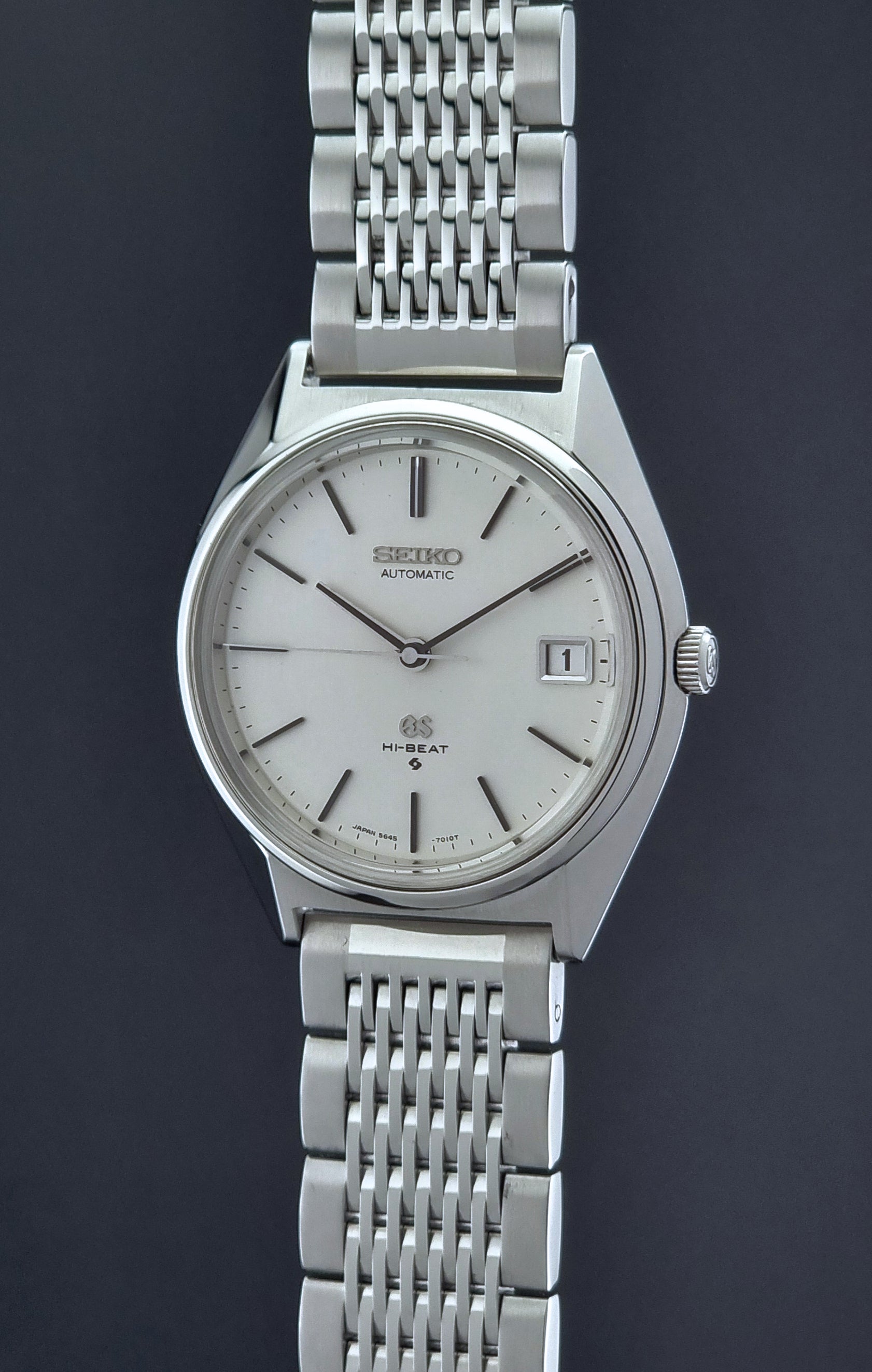 Vintage Grand Seiko Wristwatch 5646-7010 with a white face on a dark background crown side profile