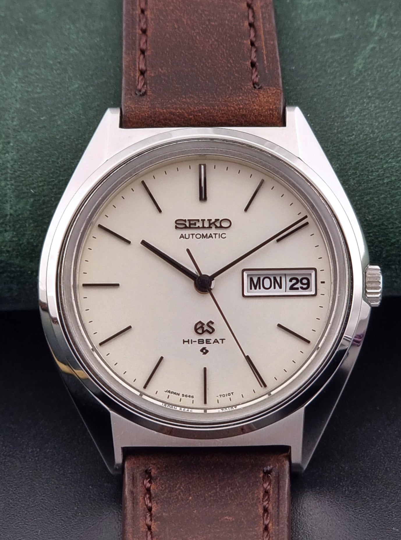 Vintage Grand Seiko Watch with brown leather strap on a green and black background