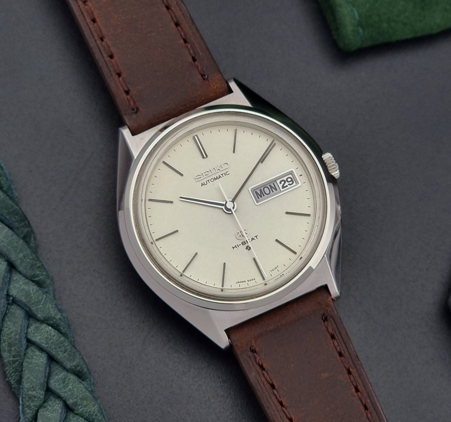 Vintage Grand Seiko Watch with brown leather strap on a gray surface