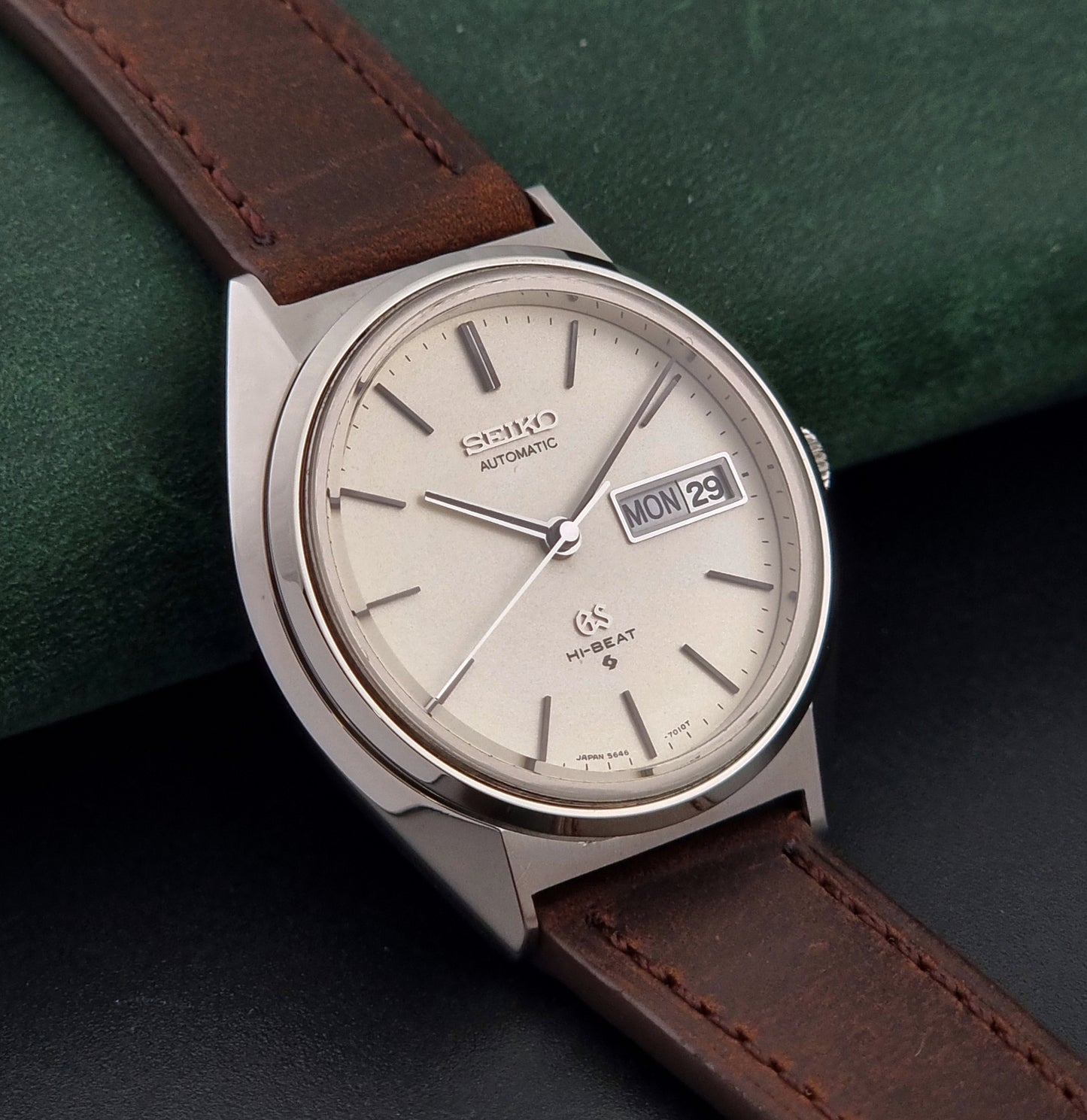 Vintage Grand Seiko Watch with brown leather strap on a green and black gradient background