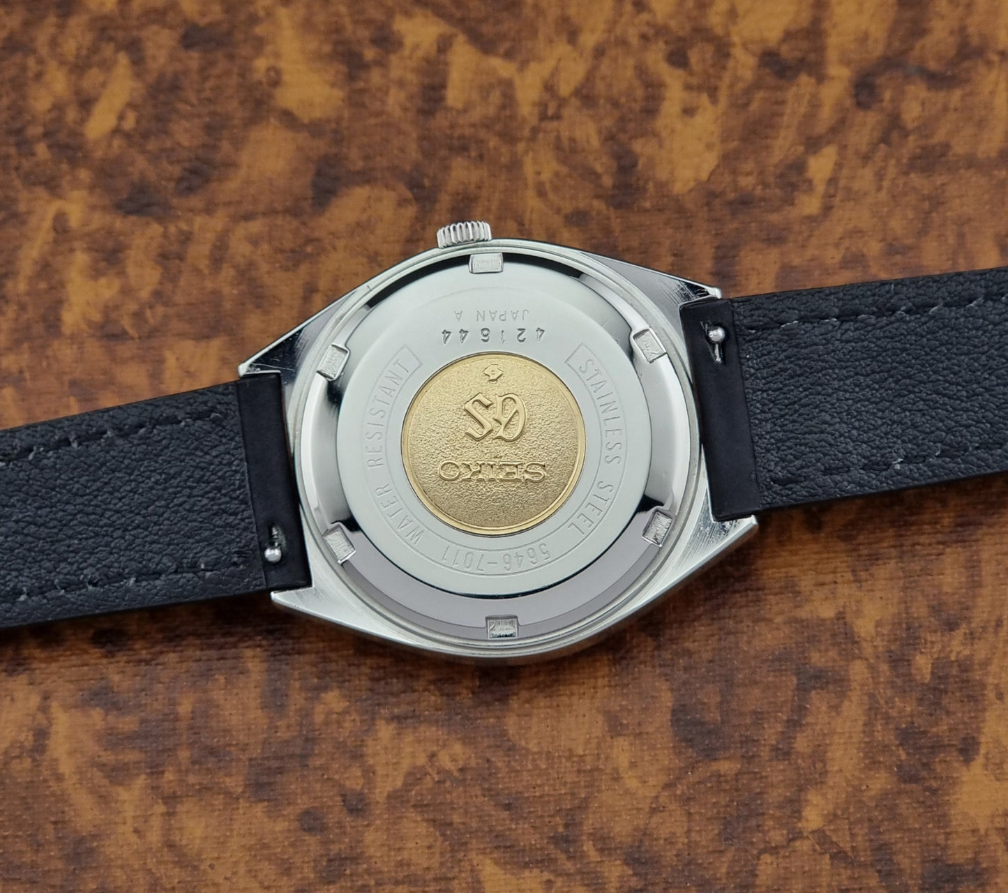 Vintage Grand Seiko 5646-7011 Wristwatch with black leather strap on a wooden surface case back