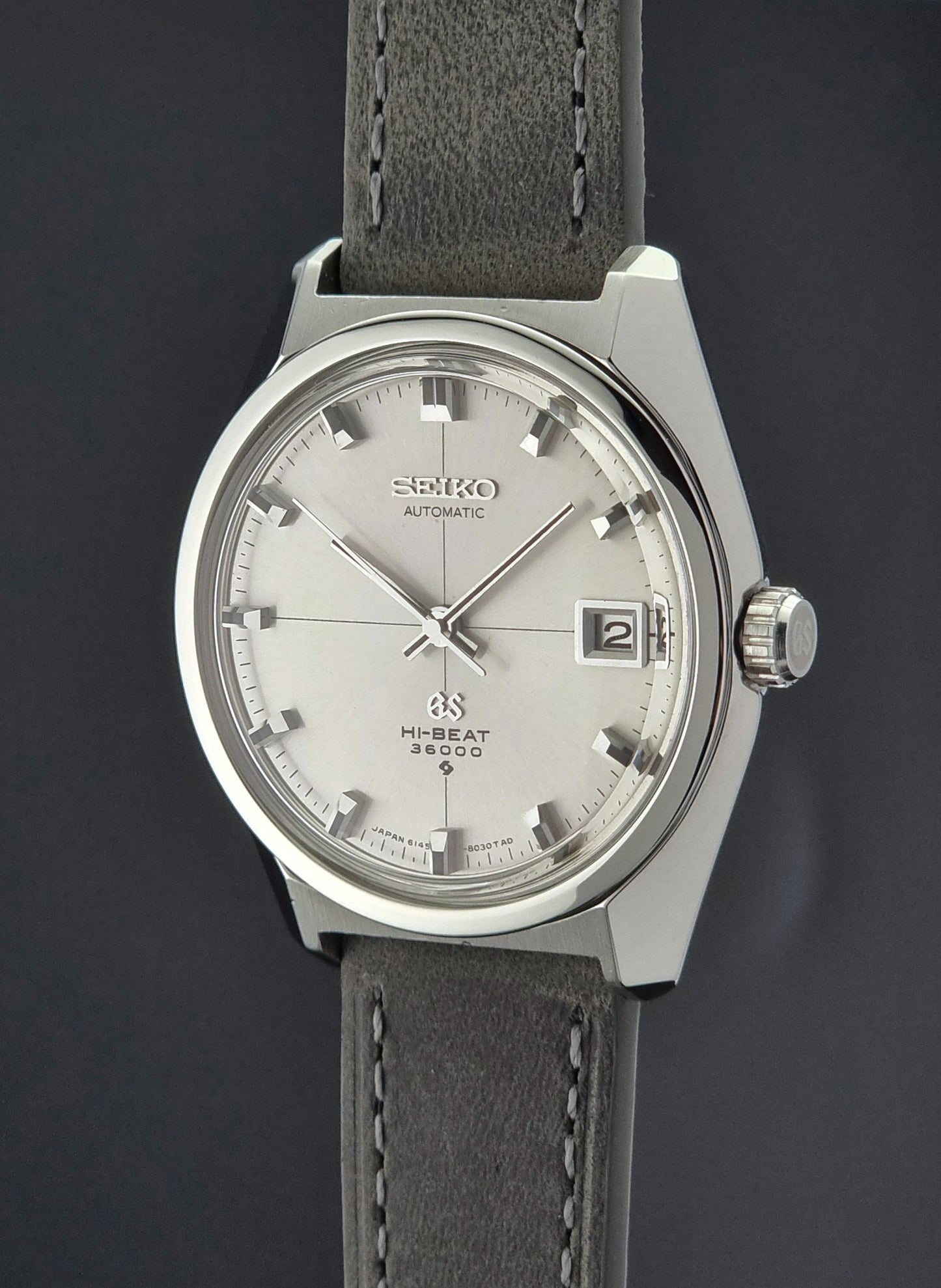 Vintage Grand Seiko watch with gray leather strap on a dark background