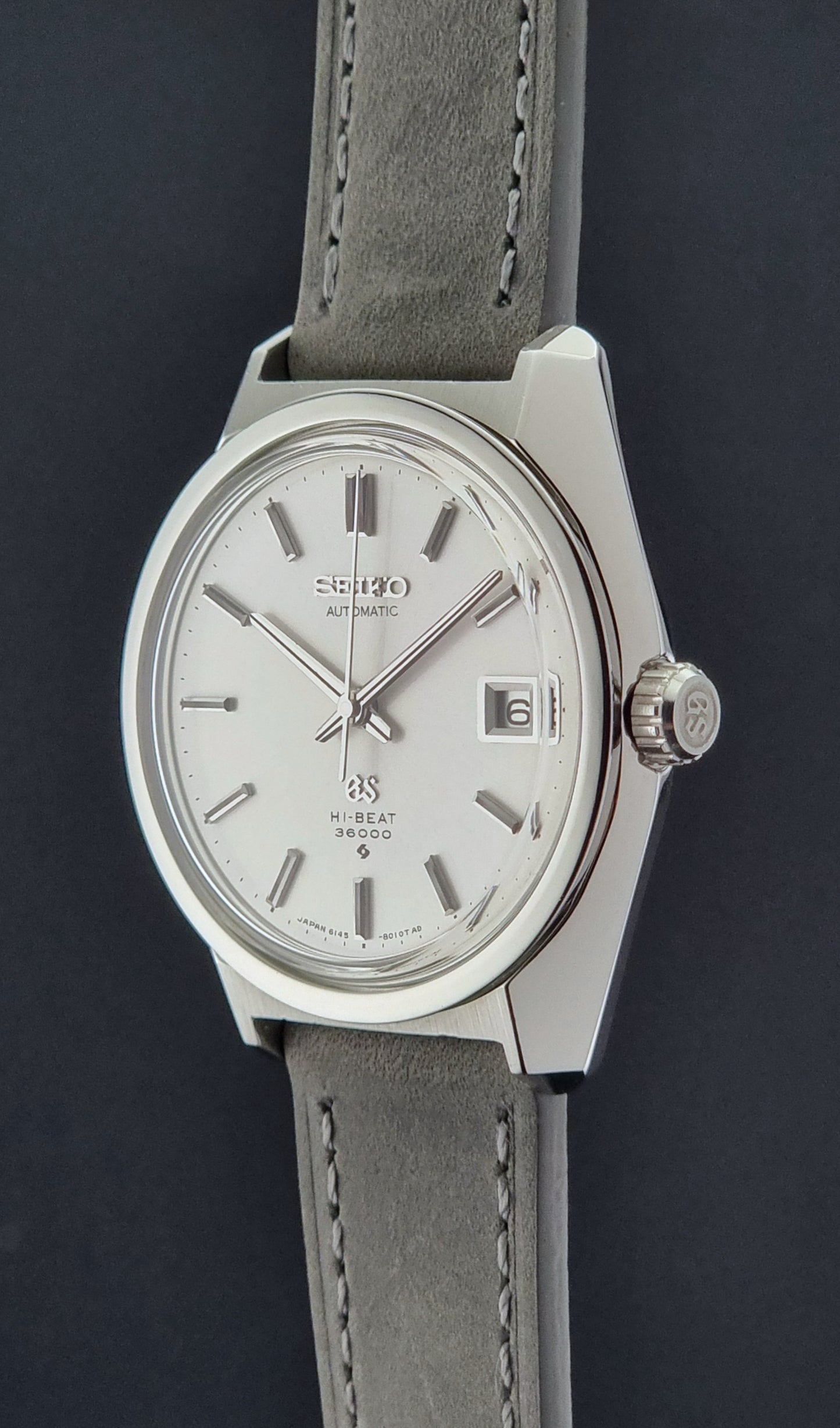 Grand Seiko 6145-8000 watch with gray strap on a dark background