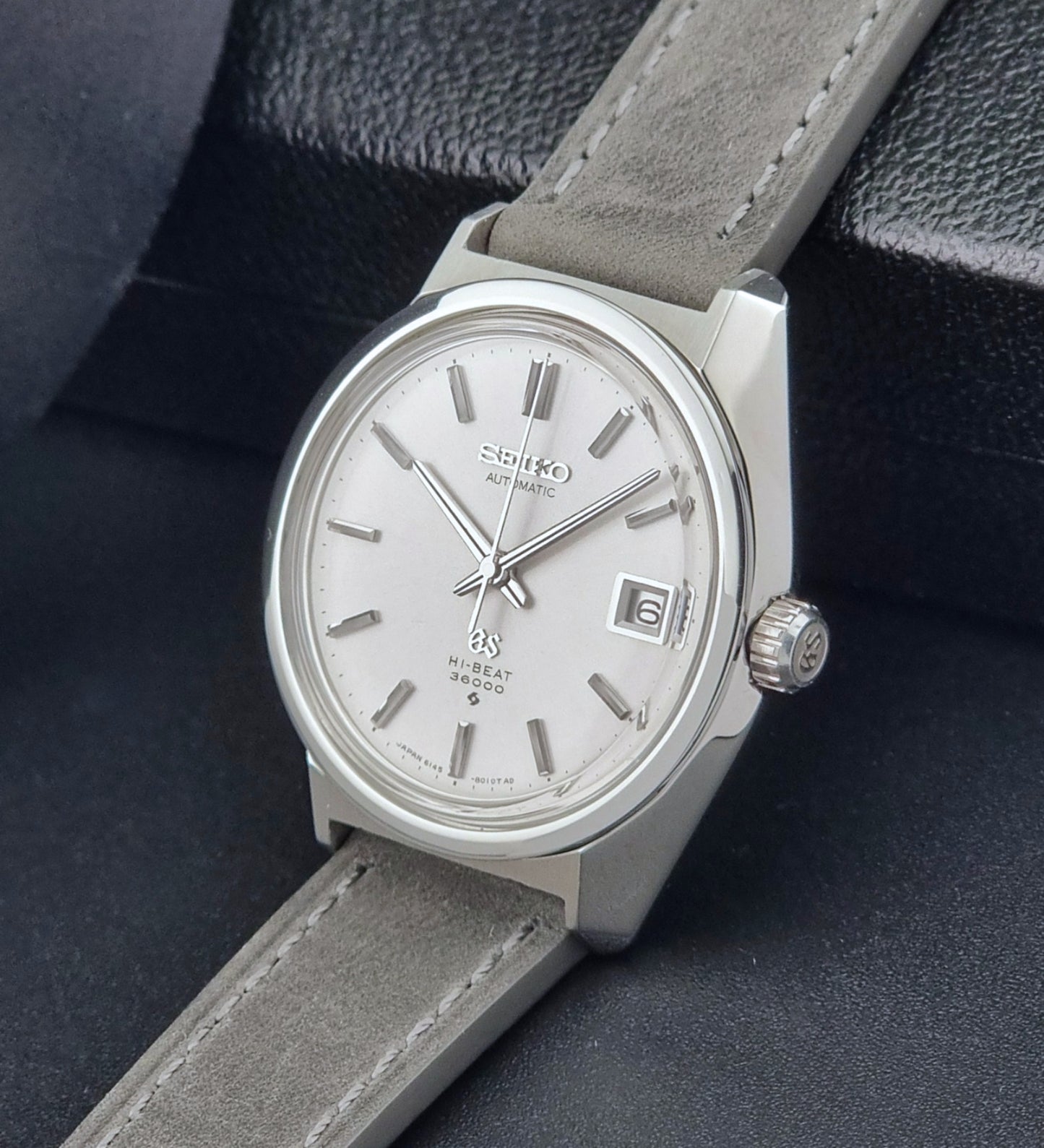 Grand Seiko 6145-8000 watch with gray strap on a dark background