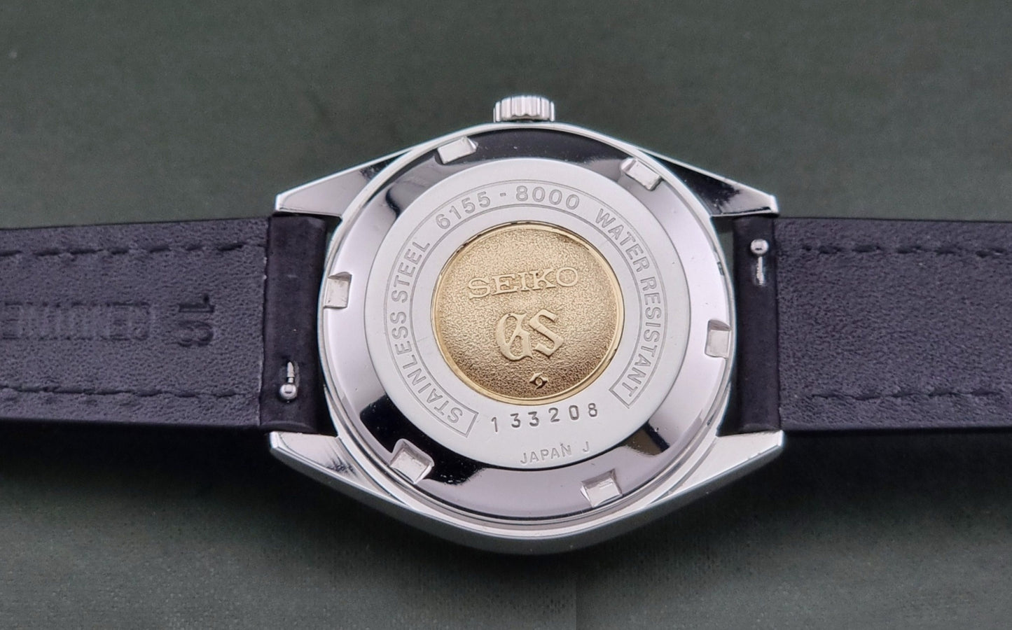 Close-up of a watch case with Seiko branding on a dark background