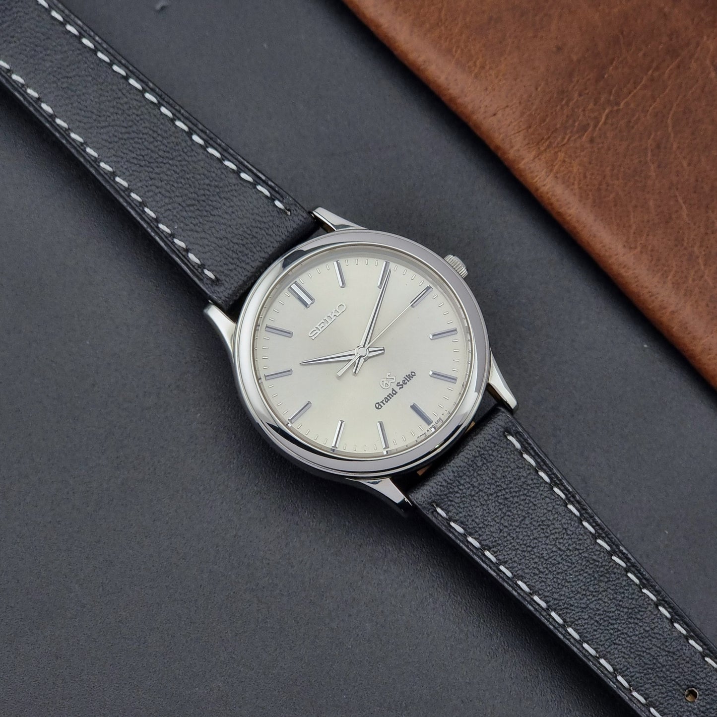 Grand Seiko SBGF015 Wristwatch 8J55-0A10 quartz on a black leather strap on a gray surface