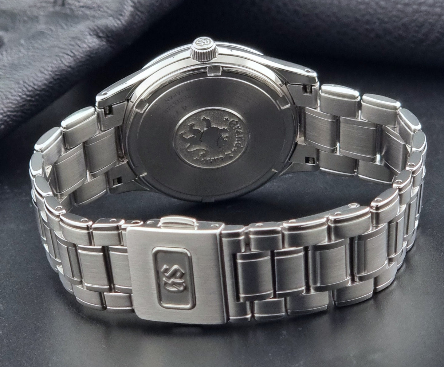 Grand Seiko SBGF027 quartz watch 8J55-0AA0 watch on a dark textured background case back view