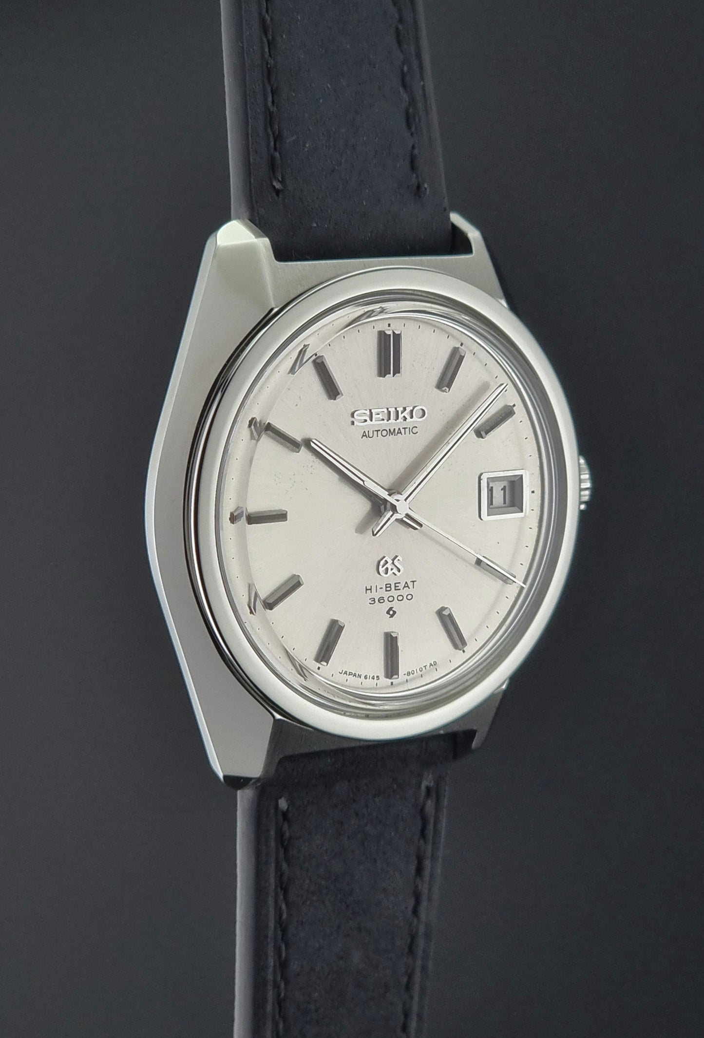 Seiko watch with black leather strap on a dark background