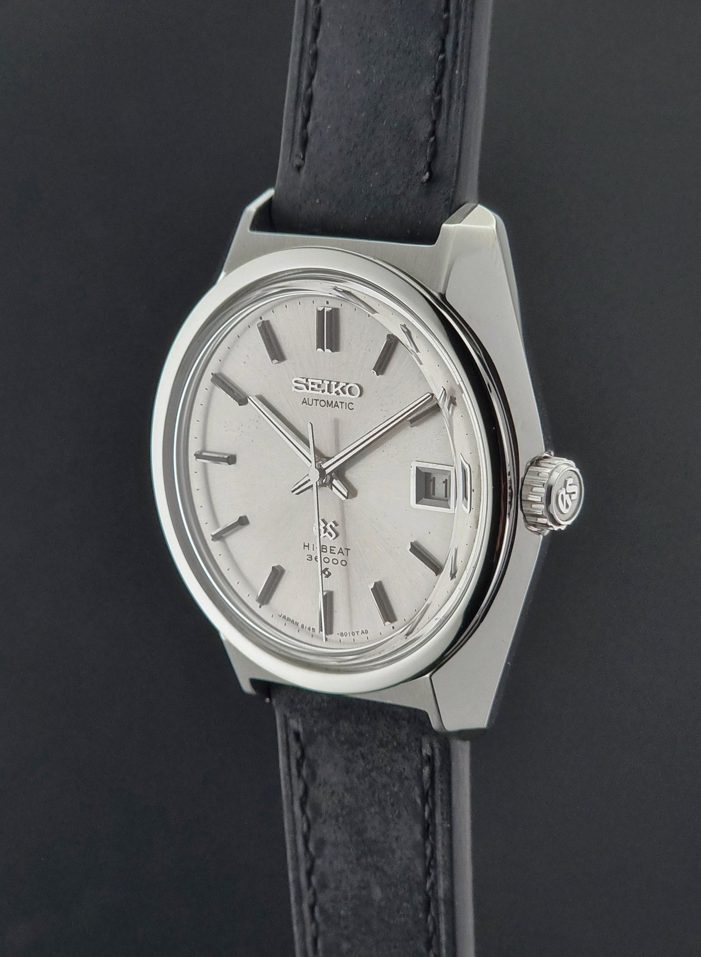 Seiko wristwatch with black leather strap on a dark background