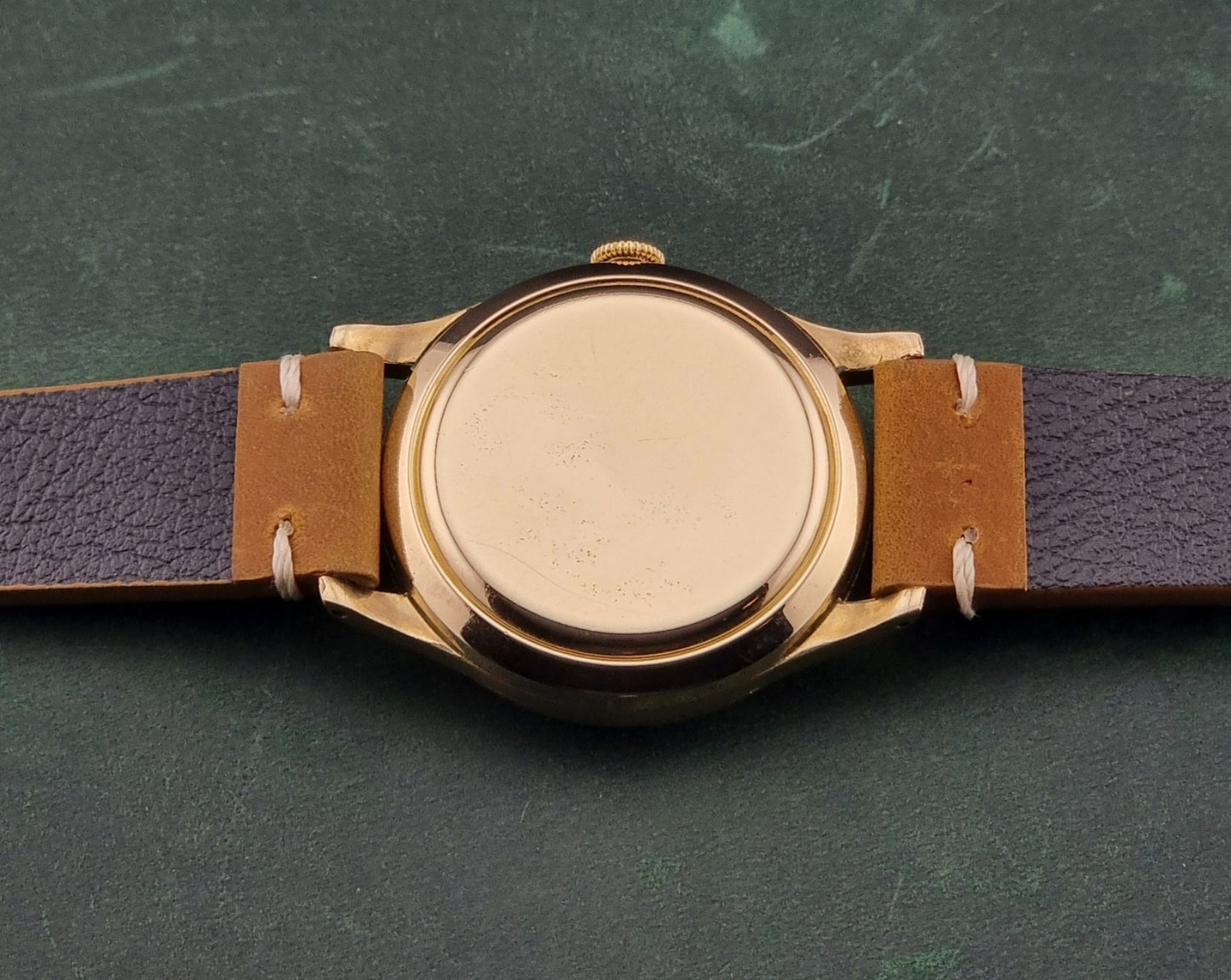 A vintage gold-plated IWC watch caseback