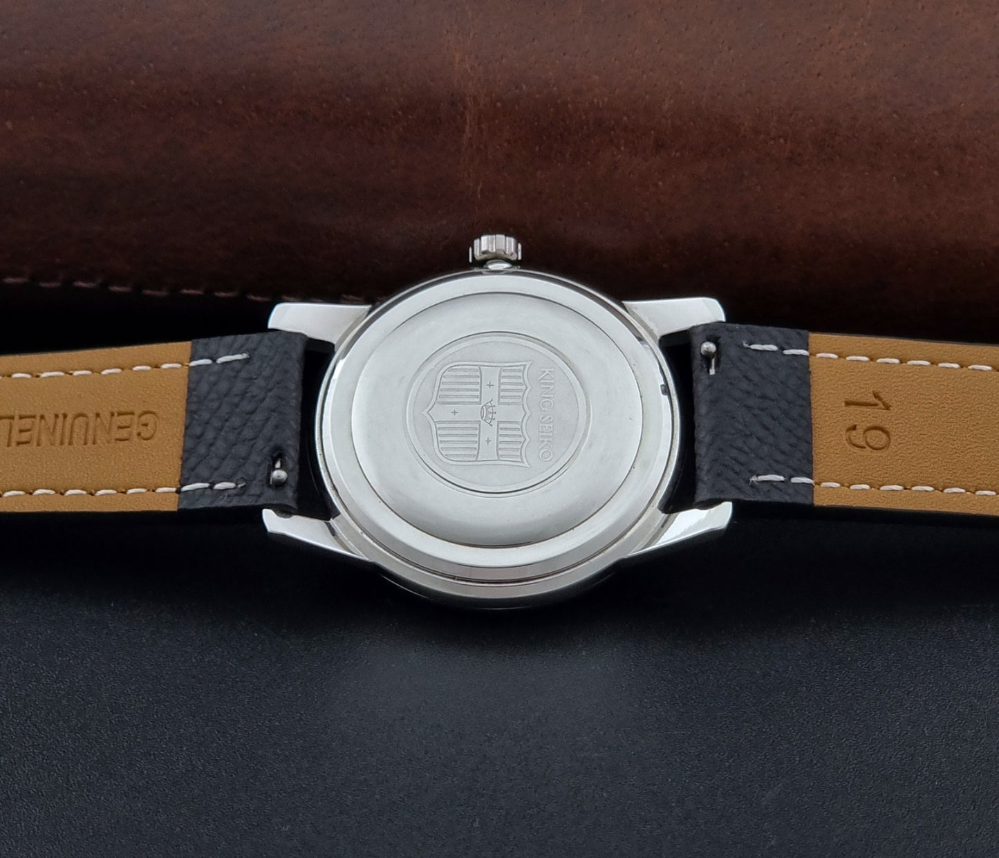 Vintage King Seiko Wristwatch 15034 with a black leather strap on a gray surface case back view