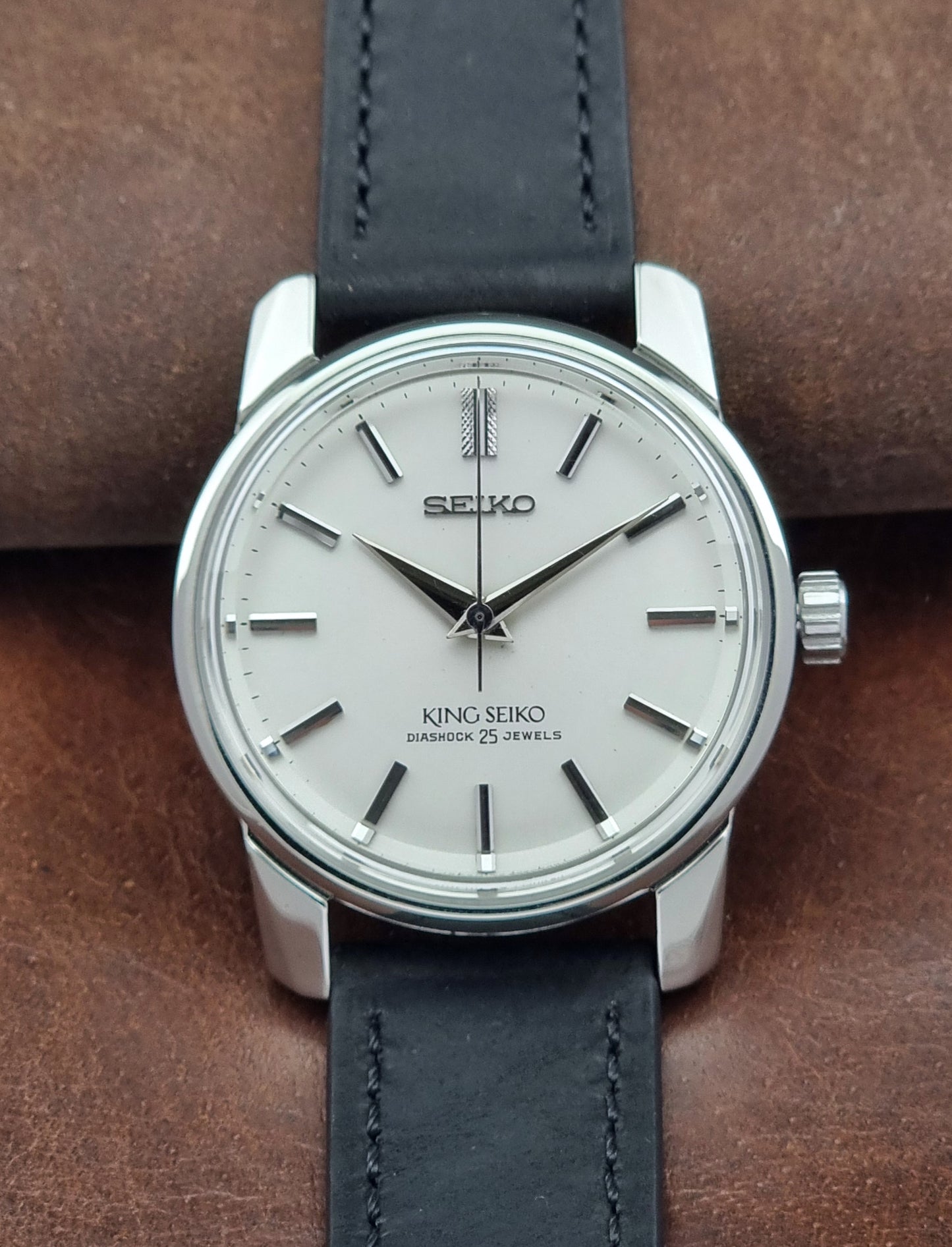 Vintage King Seiko 44-999 Watch with black leather strap on a brown background