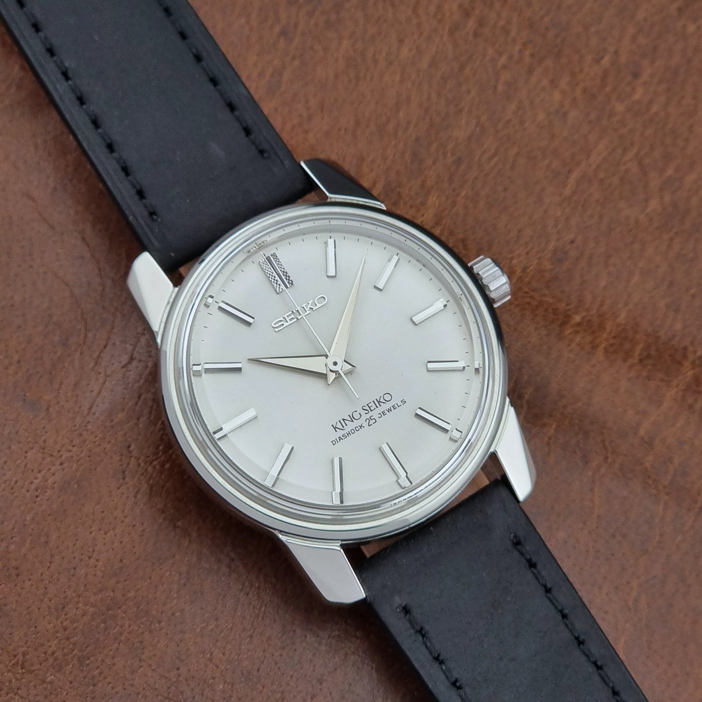 Vintage King Seiko 44-999 Watch with black leather strap on a brown surface