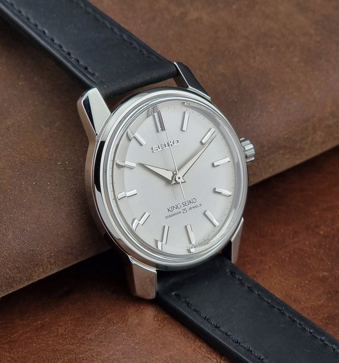Vintage King Seiko 44-999 Watch with black leather strap on a brown leather surface