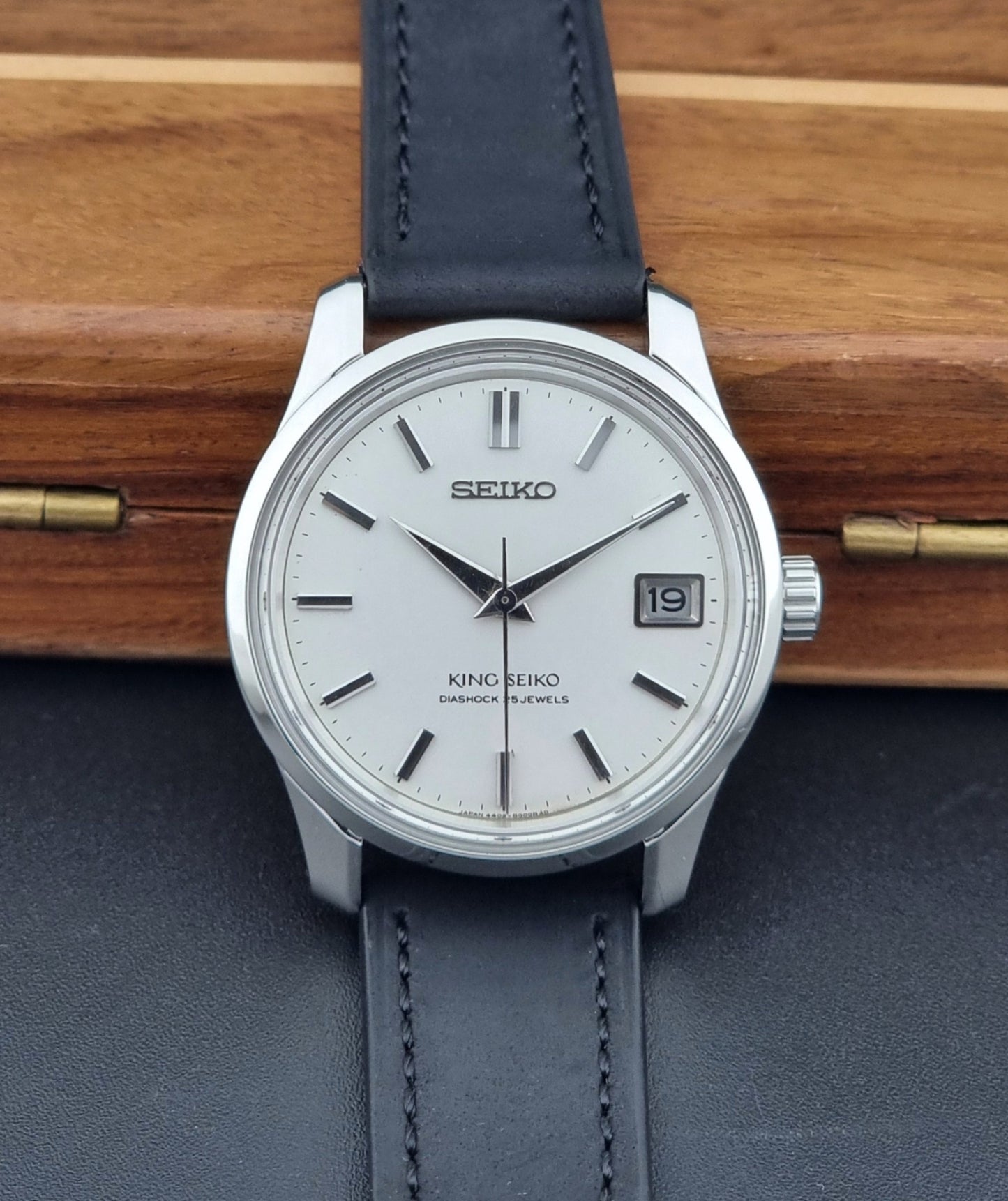 Vintage King Seiko 4402-8000 watch with a blue leather strap on a wooden surface