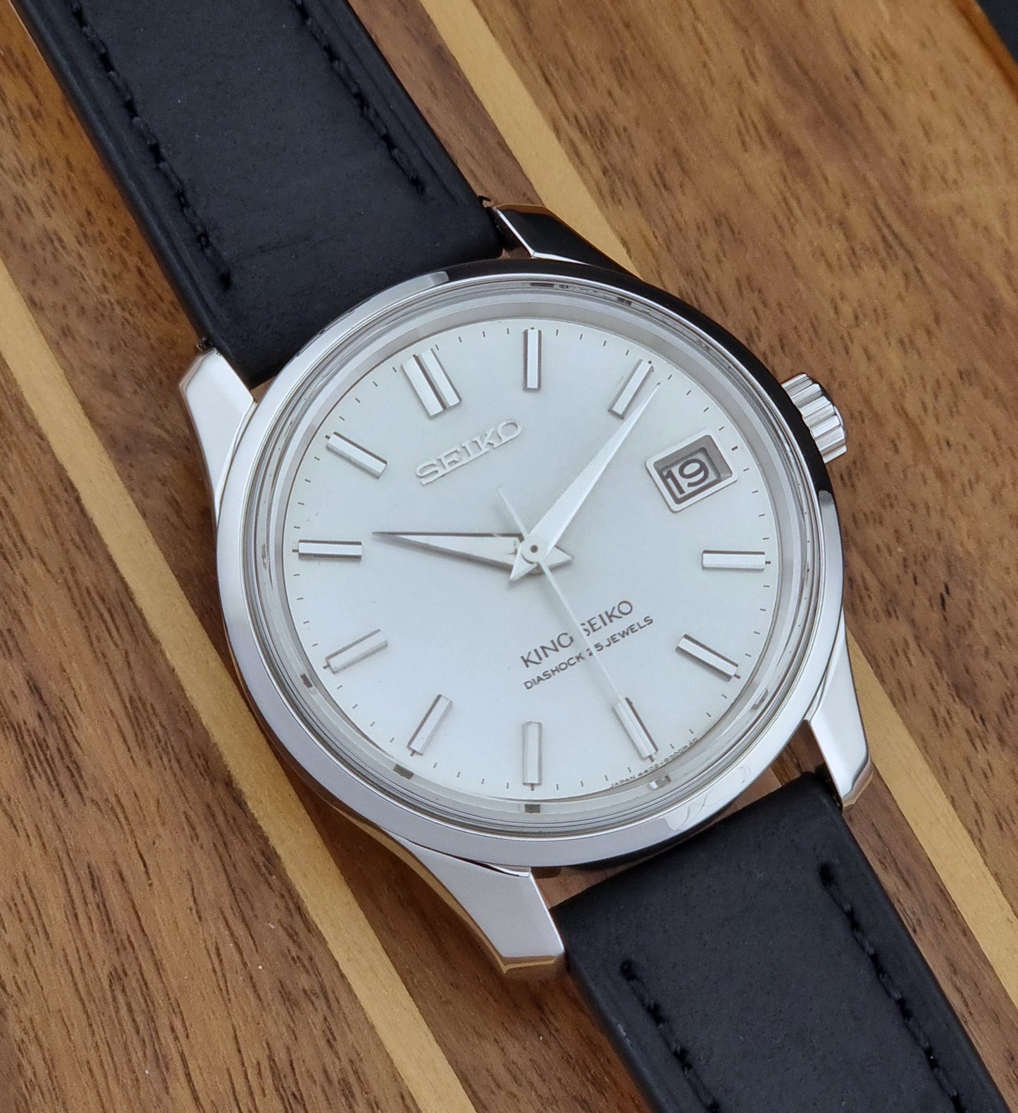 Vintage King Seiko 4402-8000 watch with black leather strap on a wooden surface